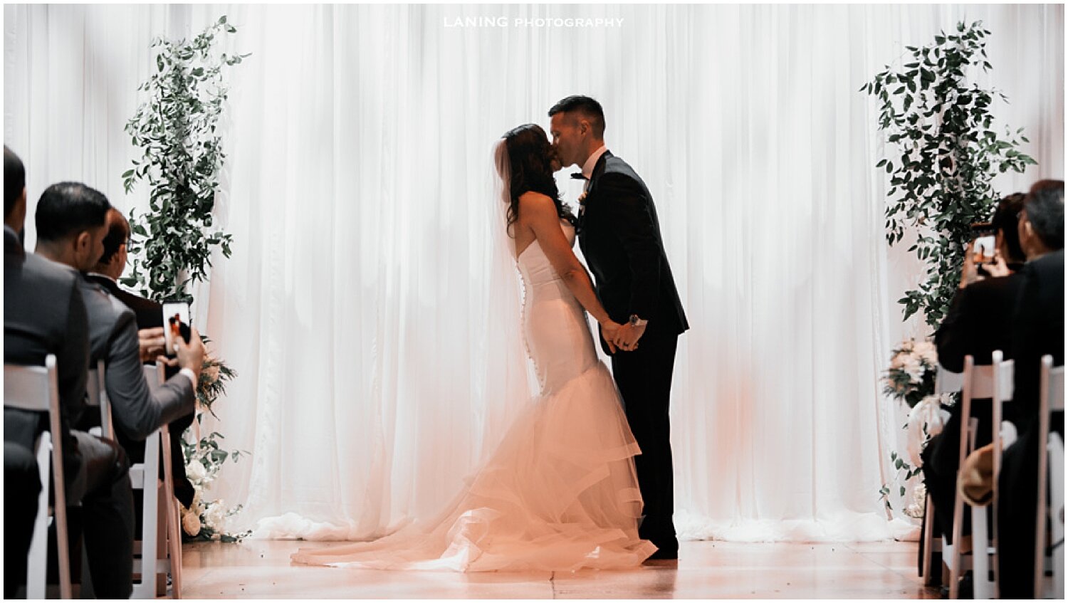  bride and groom kiss at their wedding ceremony 