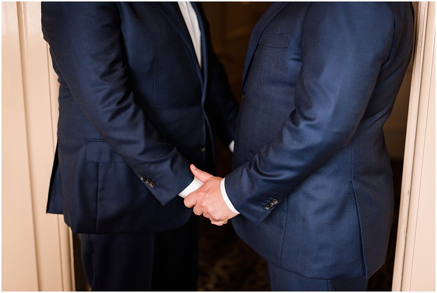  grooms holding hands before their wedding ceremony 