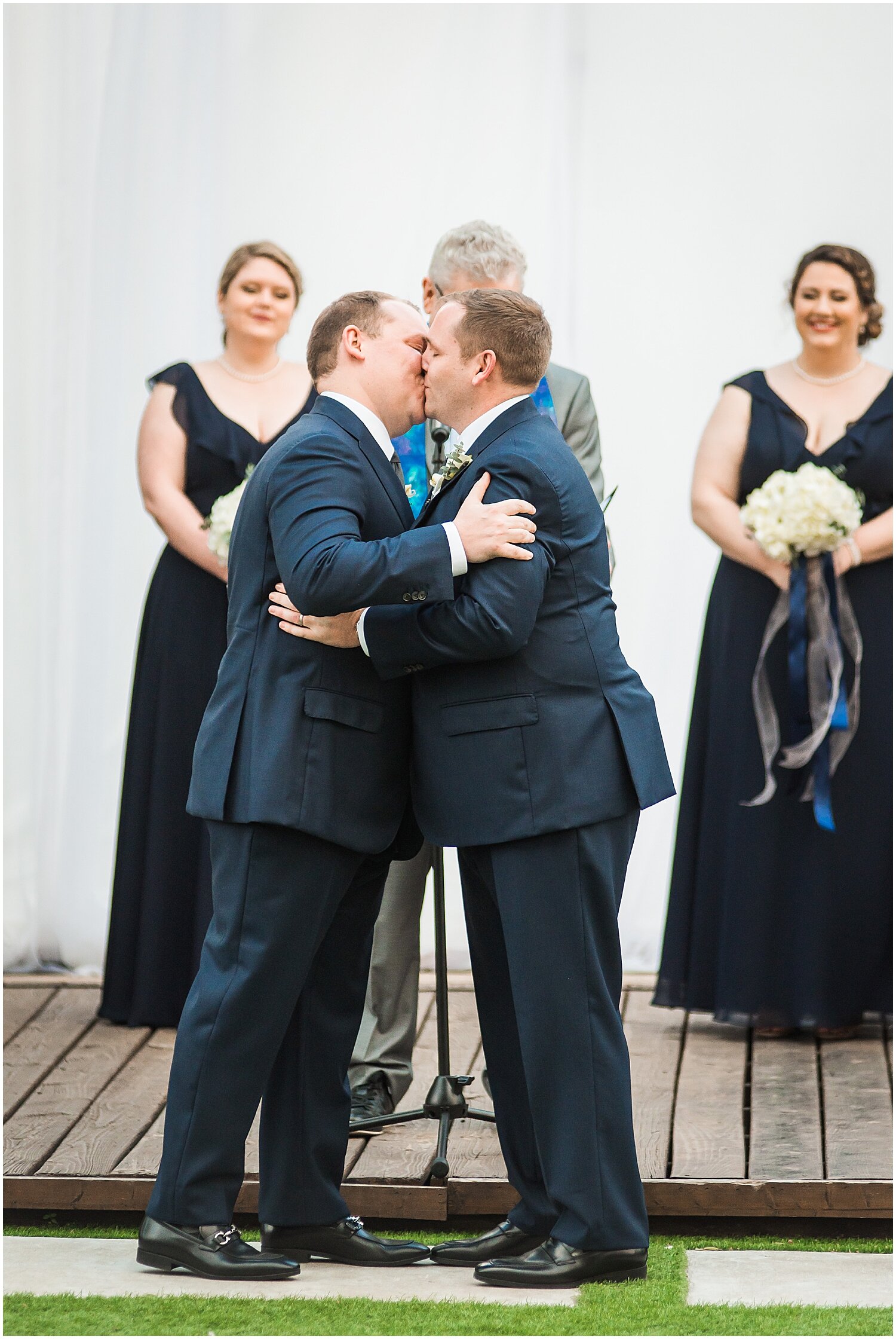  grooms kiss at their wedding ceremony 