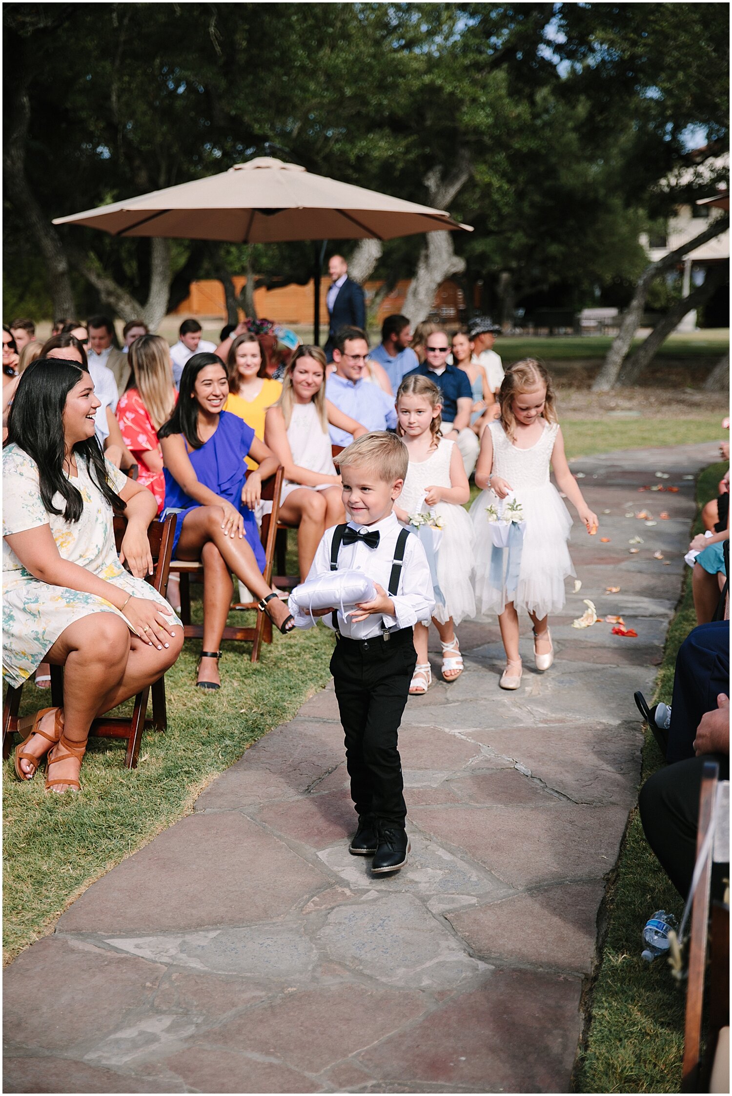  flower girls and ring bearer walking down the aisle 