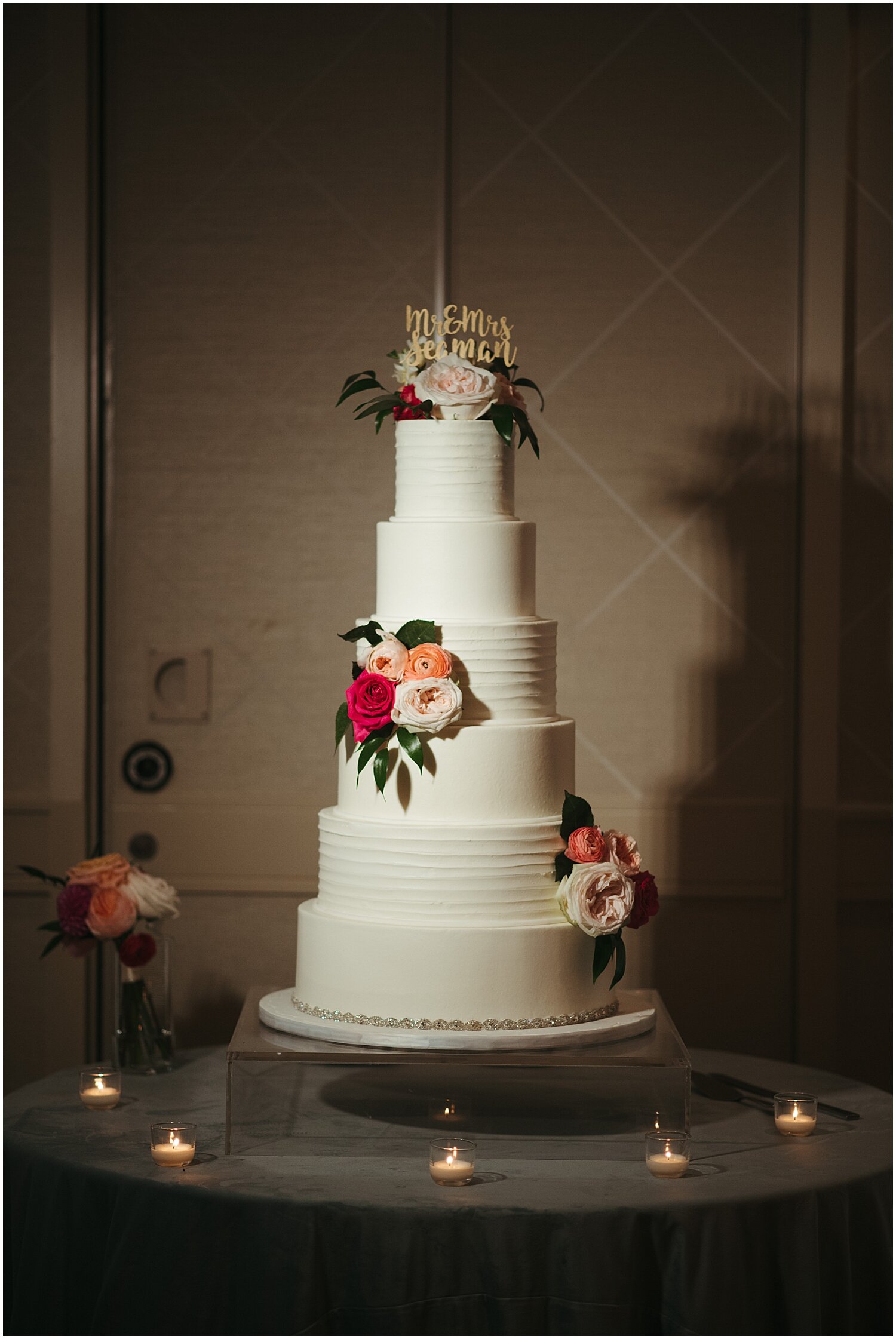  tall white wedding cake with floral decor 