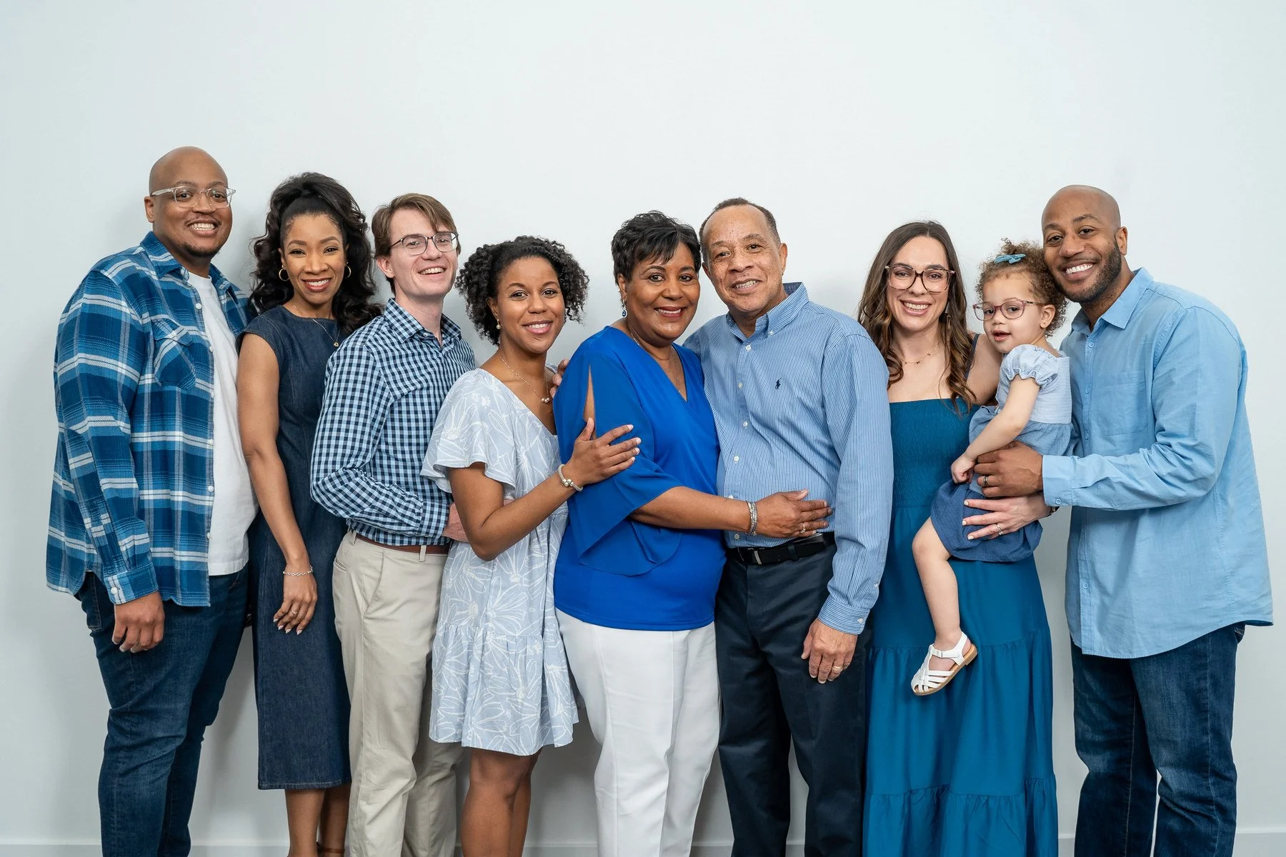 04-teresa-mansbach-extended-family-portrait-with-a-baby-against-a-blue-backdrop-id-105.jpg