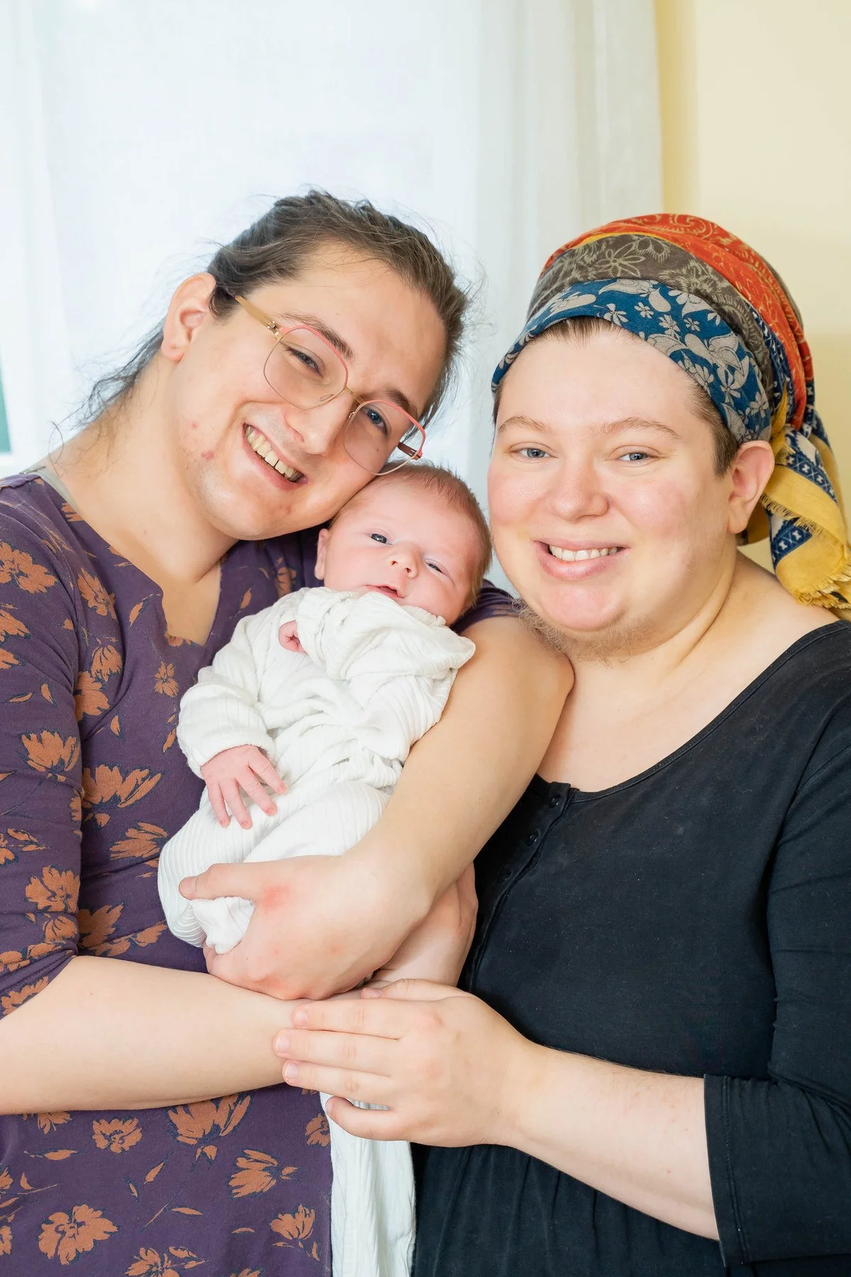 09-teresa-mansbach-two-women-smiling-with-a-newborn-baby-indoors-id-072.jpg