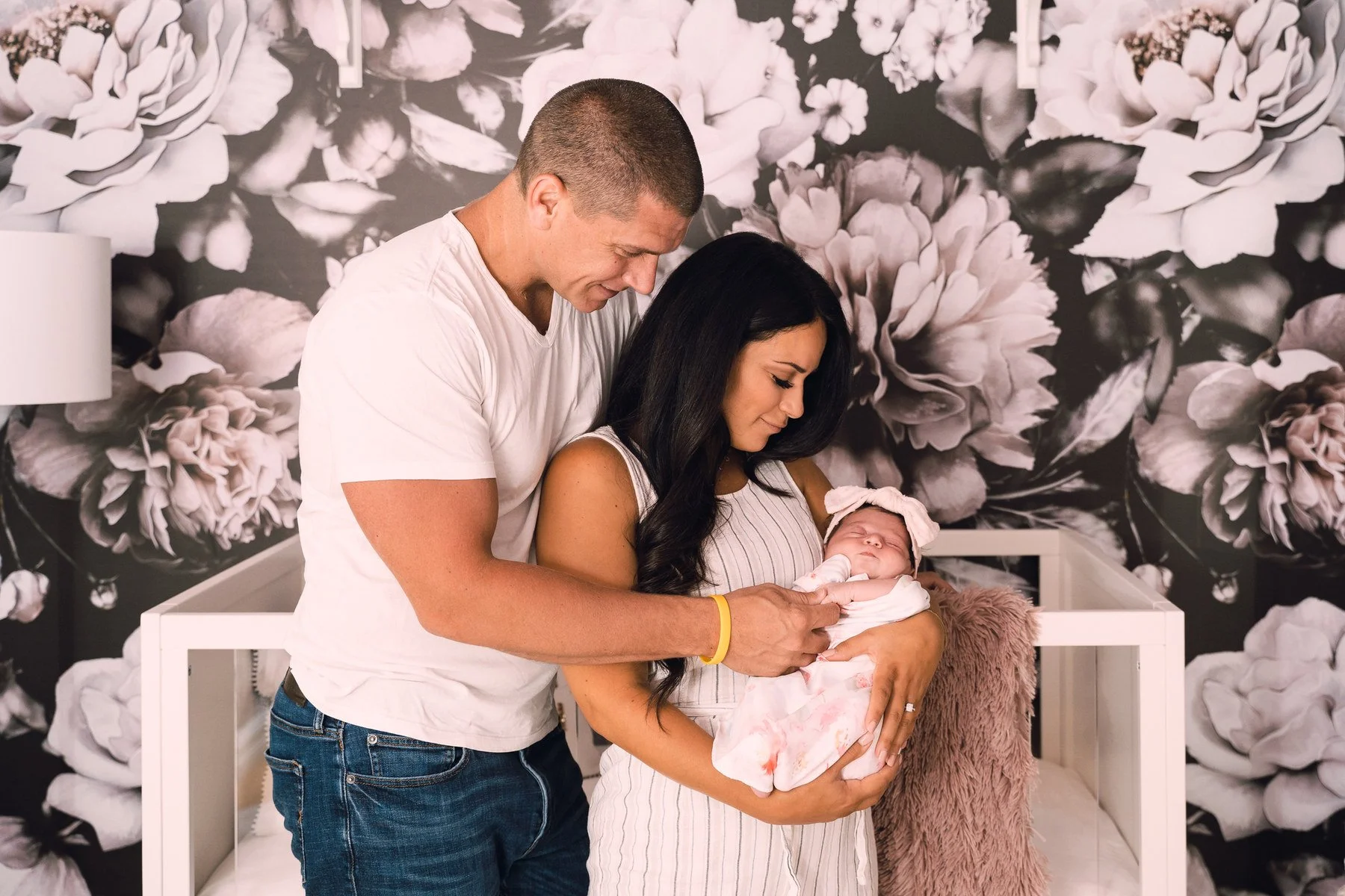11-teresa-mansbach-parents-holding-their-newborn-baby-in-a-nursery-id-103.jpg