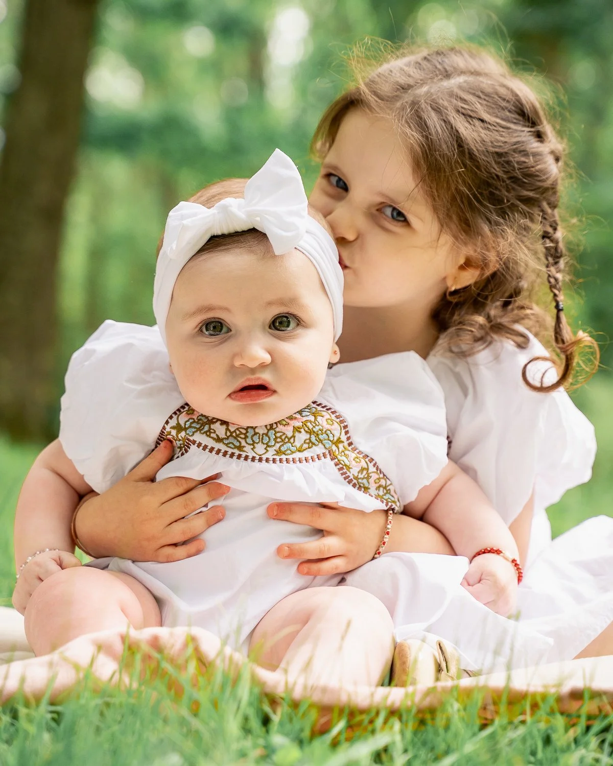16-teresa-mansbach-older-sister-hugging-a-baby-outdoors-id-242.jpg