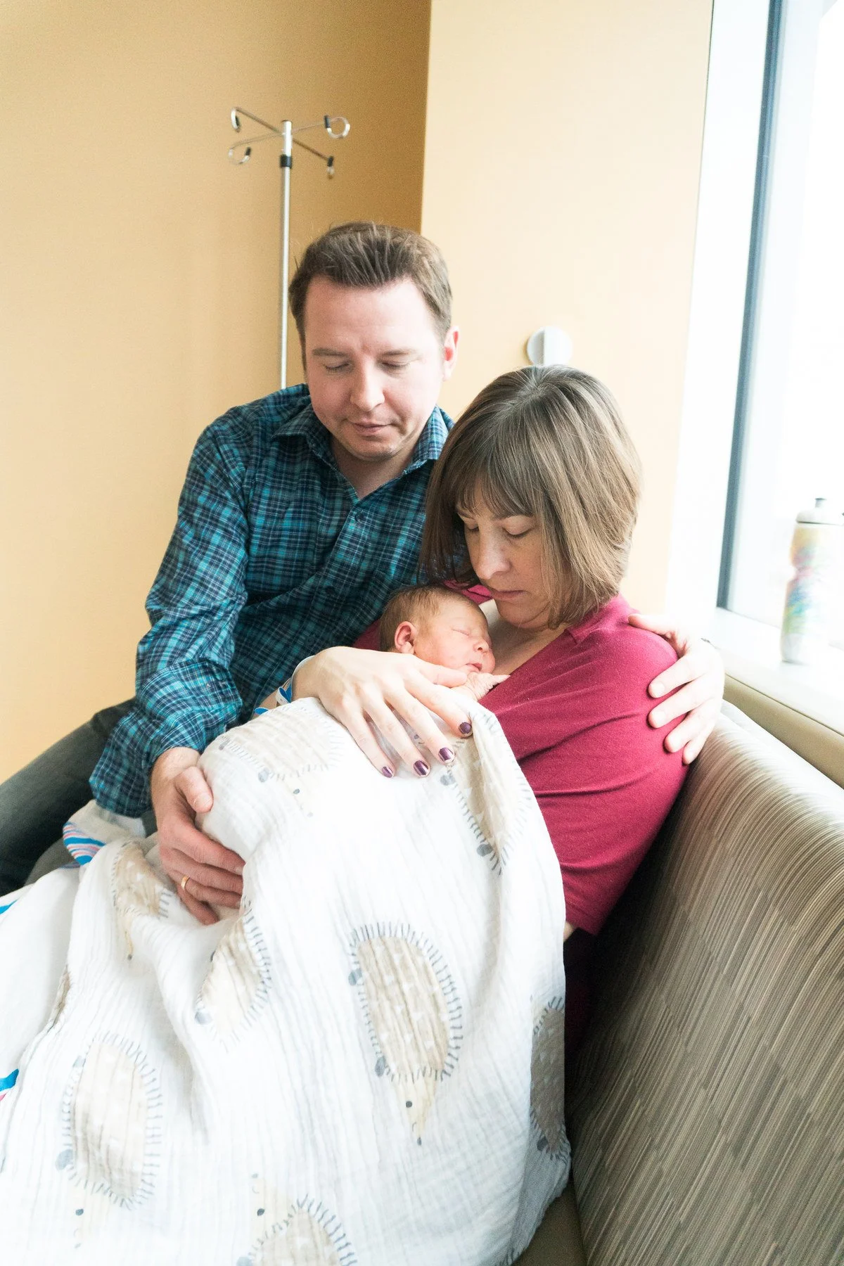 08-teresa-mansbach-parents-looking-at-their-newborn-baby-near-a-window-id-090.jpg