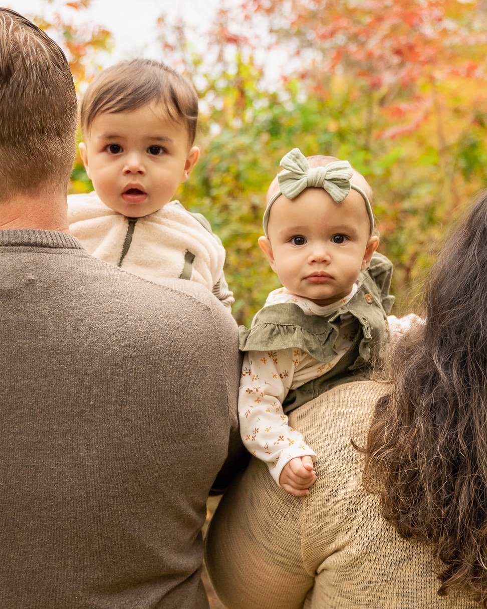15-teresa-mansbach-two-babies-held-by-family-members-outdoors-id-036.jpg