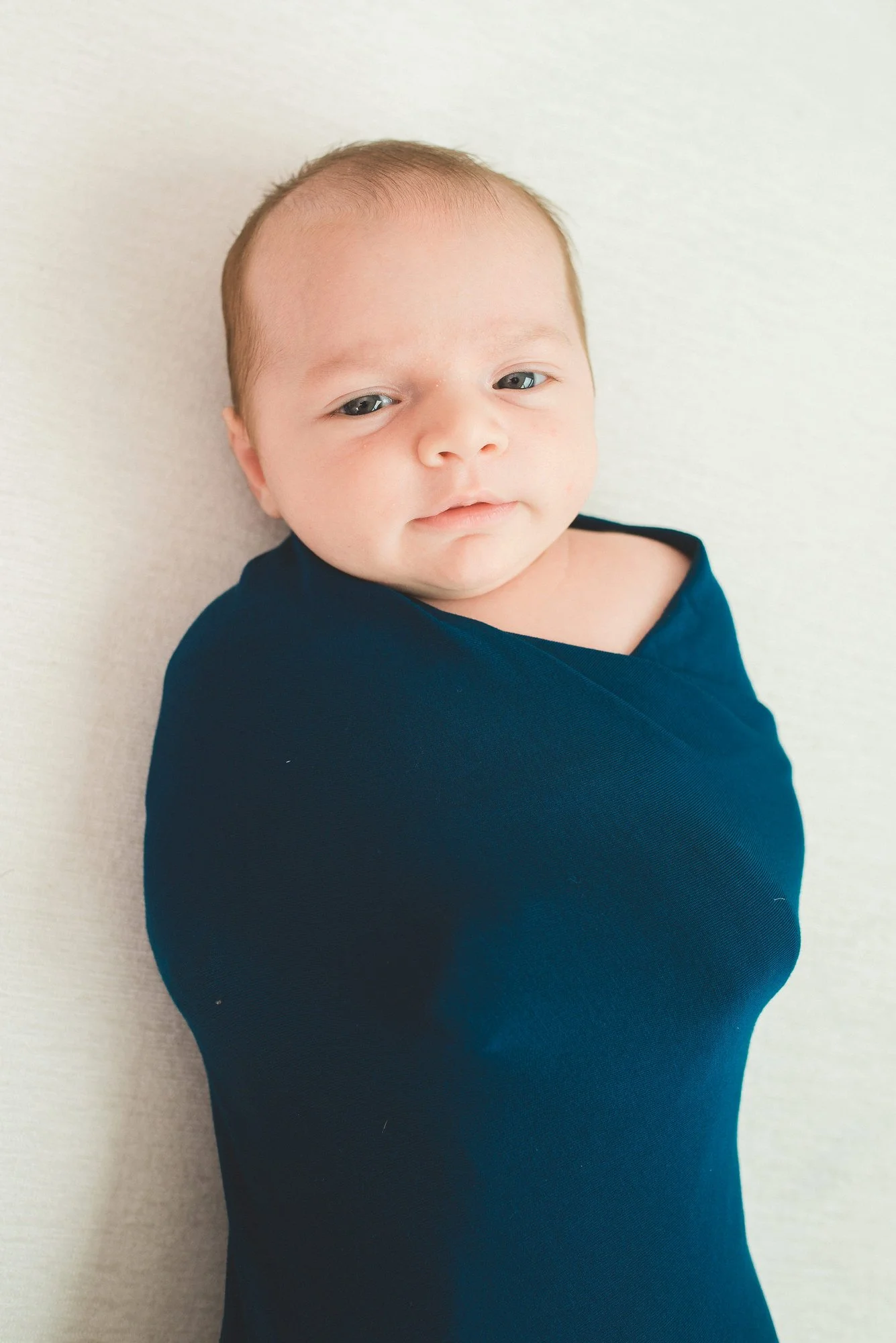 06-teresa-mansbach-newborn-baby-wrapped-in-a-dark-blue-blanket-id-062.jpg
