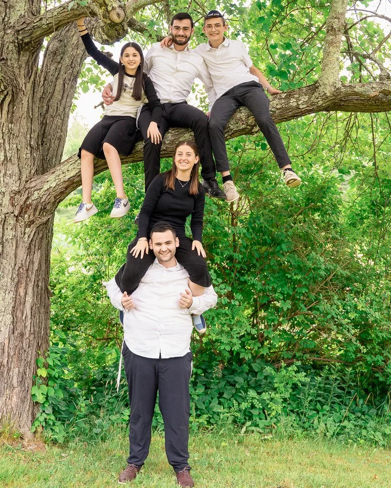 15-teresa-mansbach-family-with-older-children-posed-playfully-around-a-tree-id-108.jpg