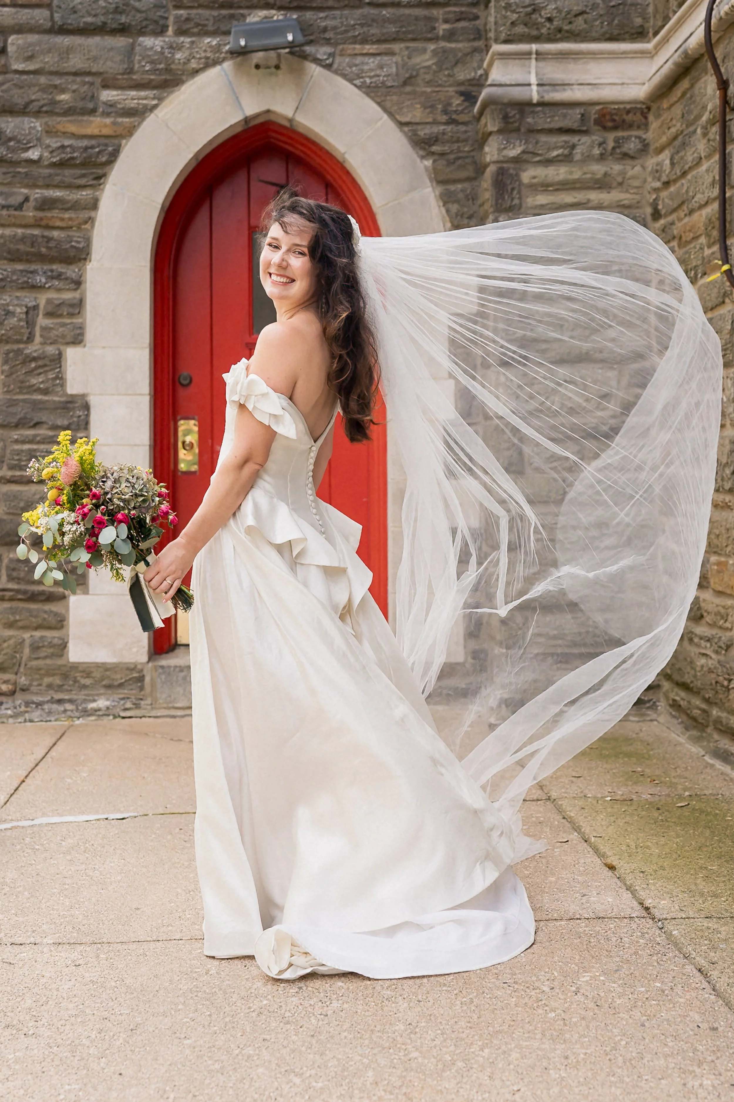 08-bride-flowing-veil-red-church-door.jpg