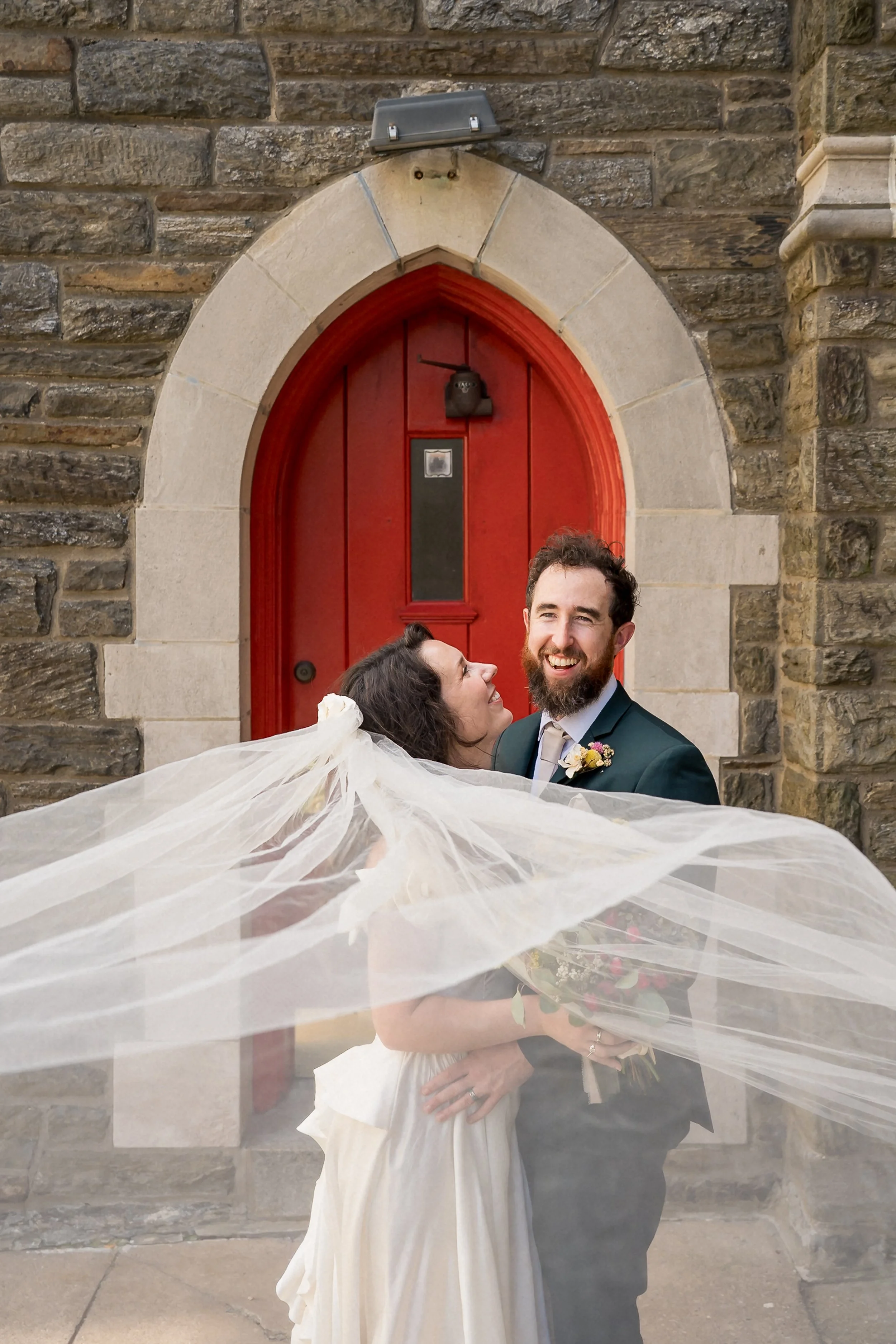 50-newlyweds-laughing-under-wedding-veil.jpg