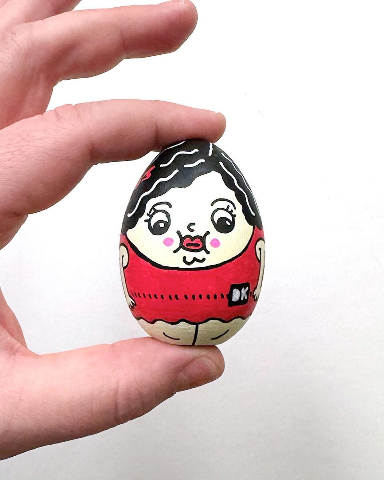 Her rosey cheeks, red dress and short legs are sure to get someones attention. This roaring twenties beauty is ready for a new home to party in. #eggprize #artegg #eggdesign #roseycheeks #cute #roaringtwenties #illustration #DK #art #sculpture #minia
