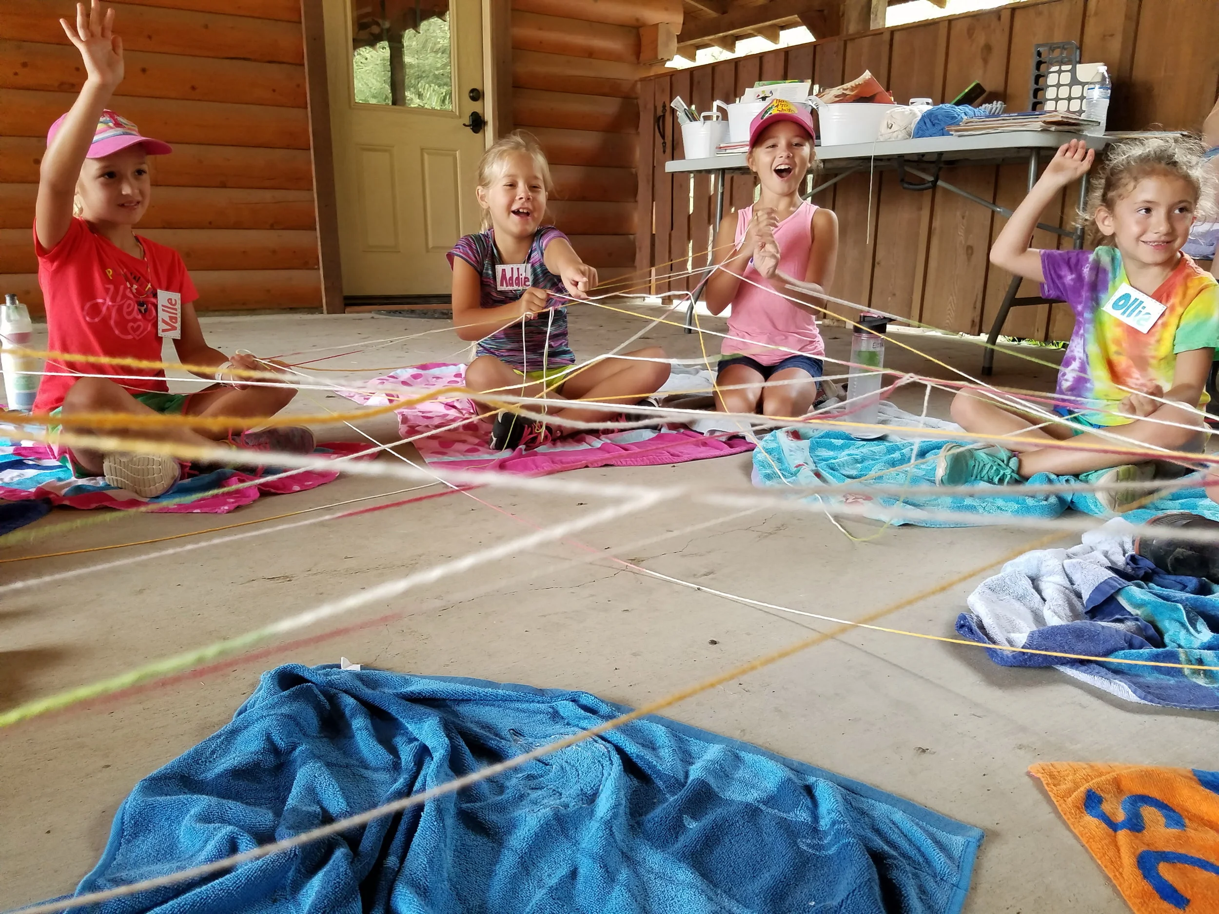 The children learned that we are all connected by things that we have in common. Farmer Amy played the This or That game with the children by asking the children to choose between two items. Those who had that choice in common passed the yarn to each other. The web continued to build and so did the laughter. 