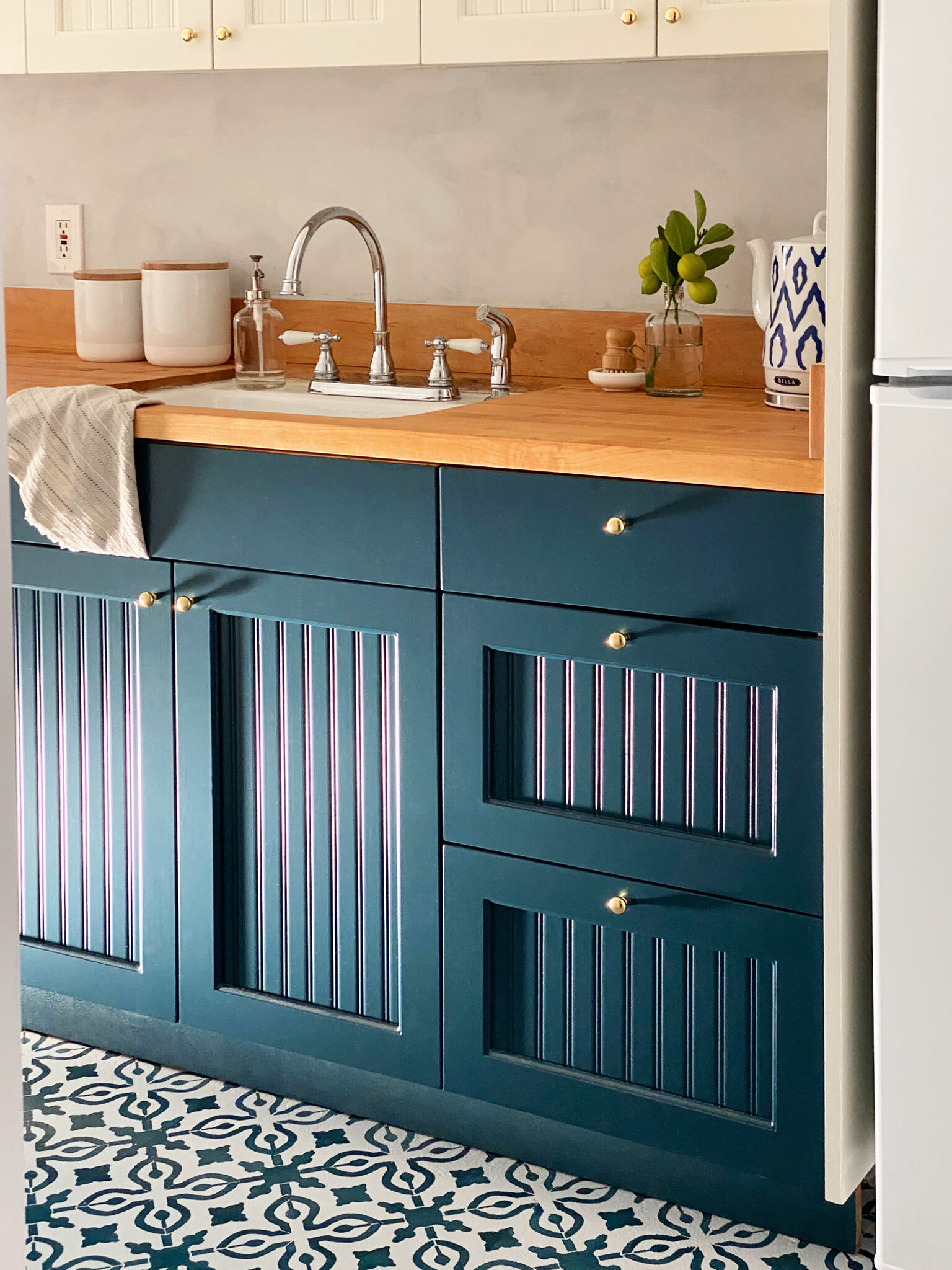  The navy beadboard cabinets and gold hardware catch the afternoon light. 
