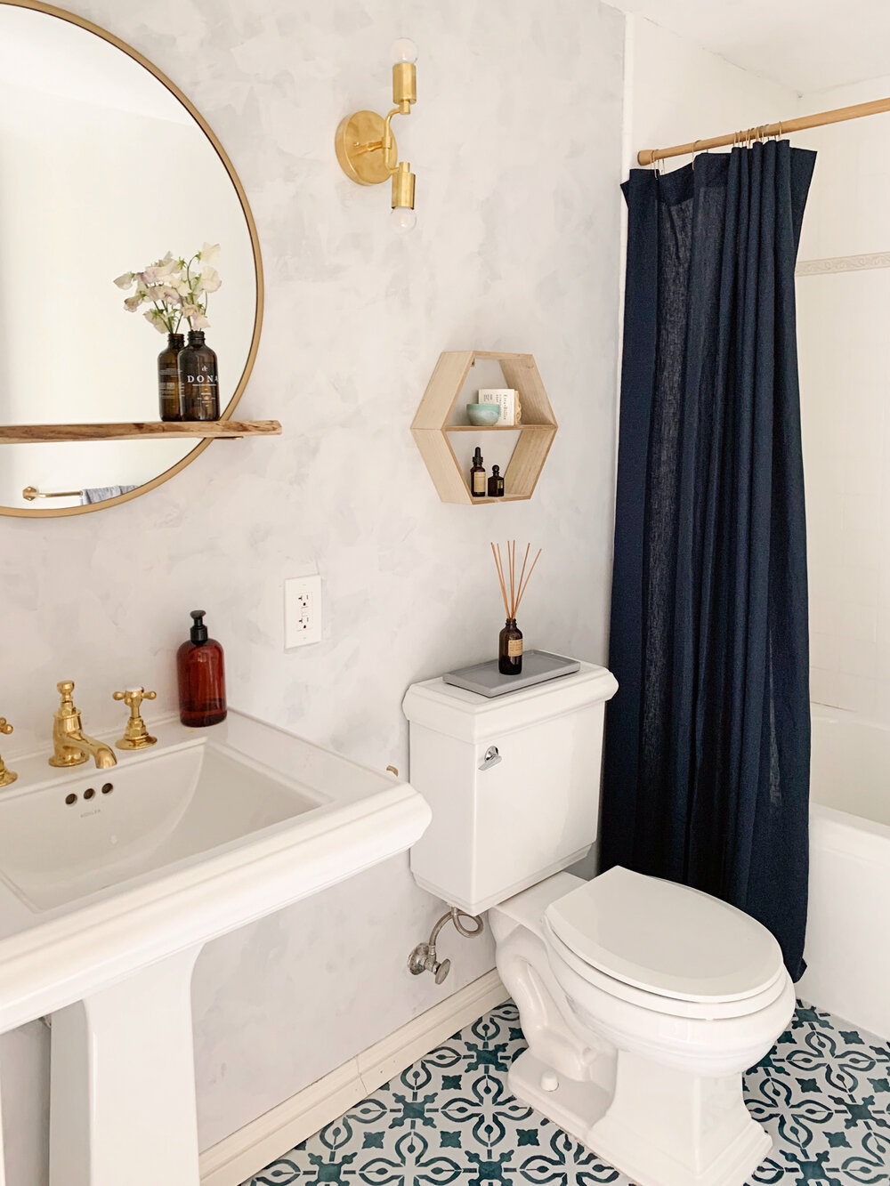  The navy linen shower curtain matches the patterned floors and adds depth to the light walls. 