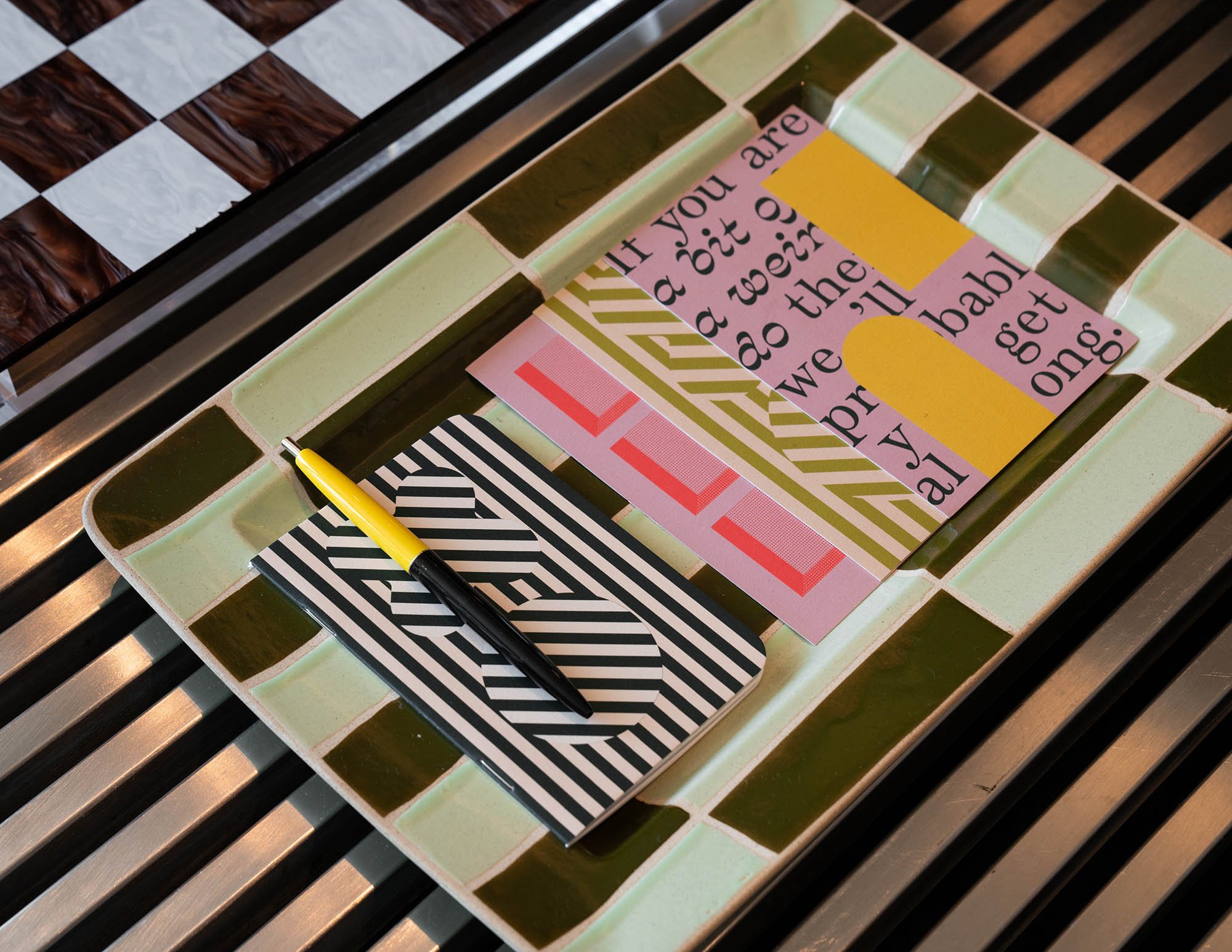 Vignette showing mized patterns of coffee table and colourful notebook in a suite at the Drake Hotel