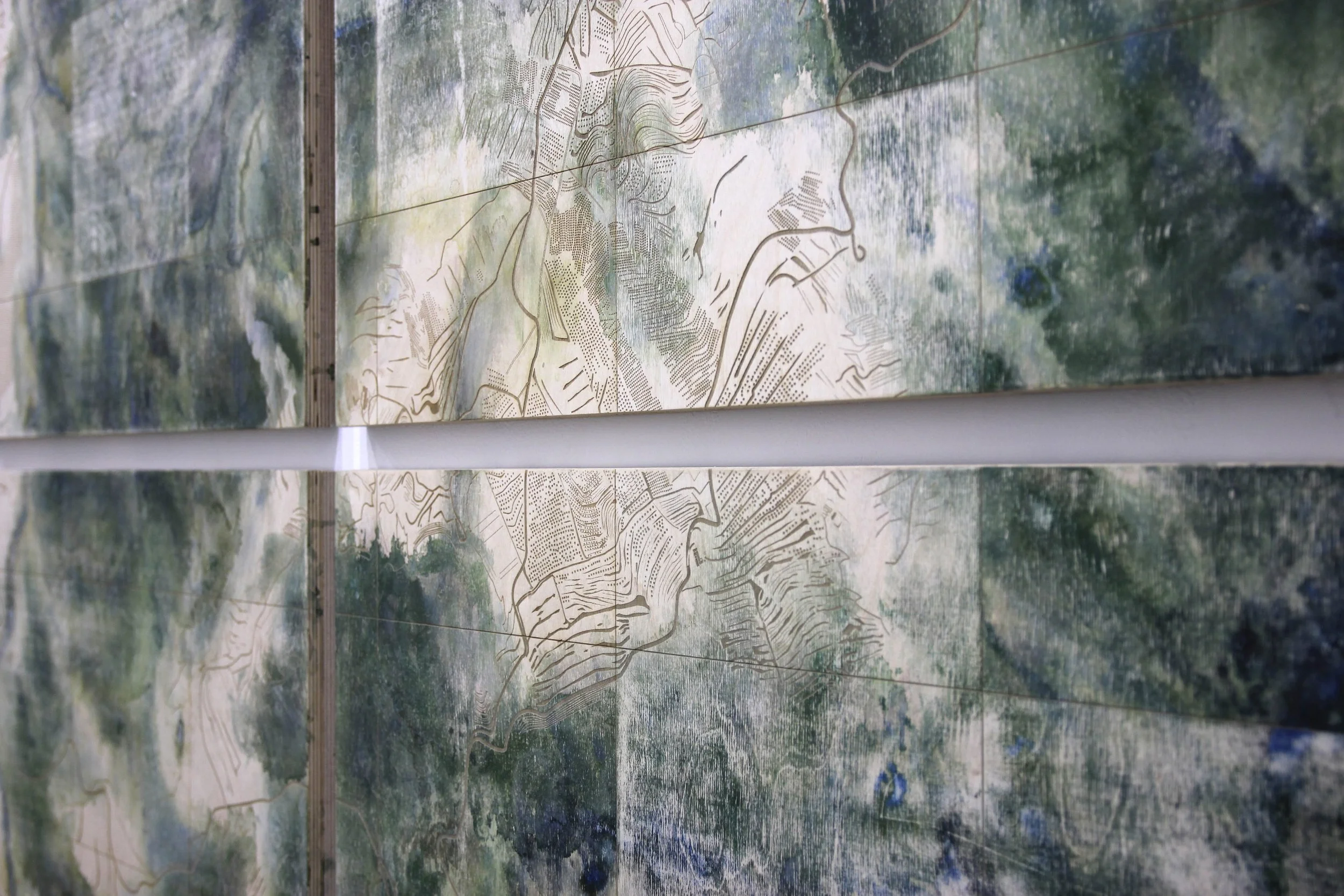  Thin watery paint washes across 12mm plywood. A laser is programmed to trace and engrave satellite imagery of human interventions in the landscape. The plywood is sanded to reveal the archaeology of the wood’s industrial production process. Layers o