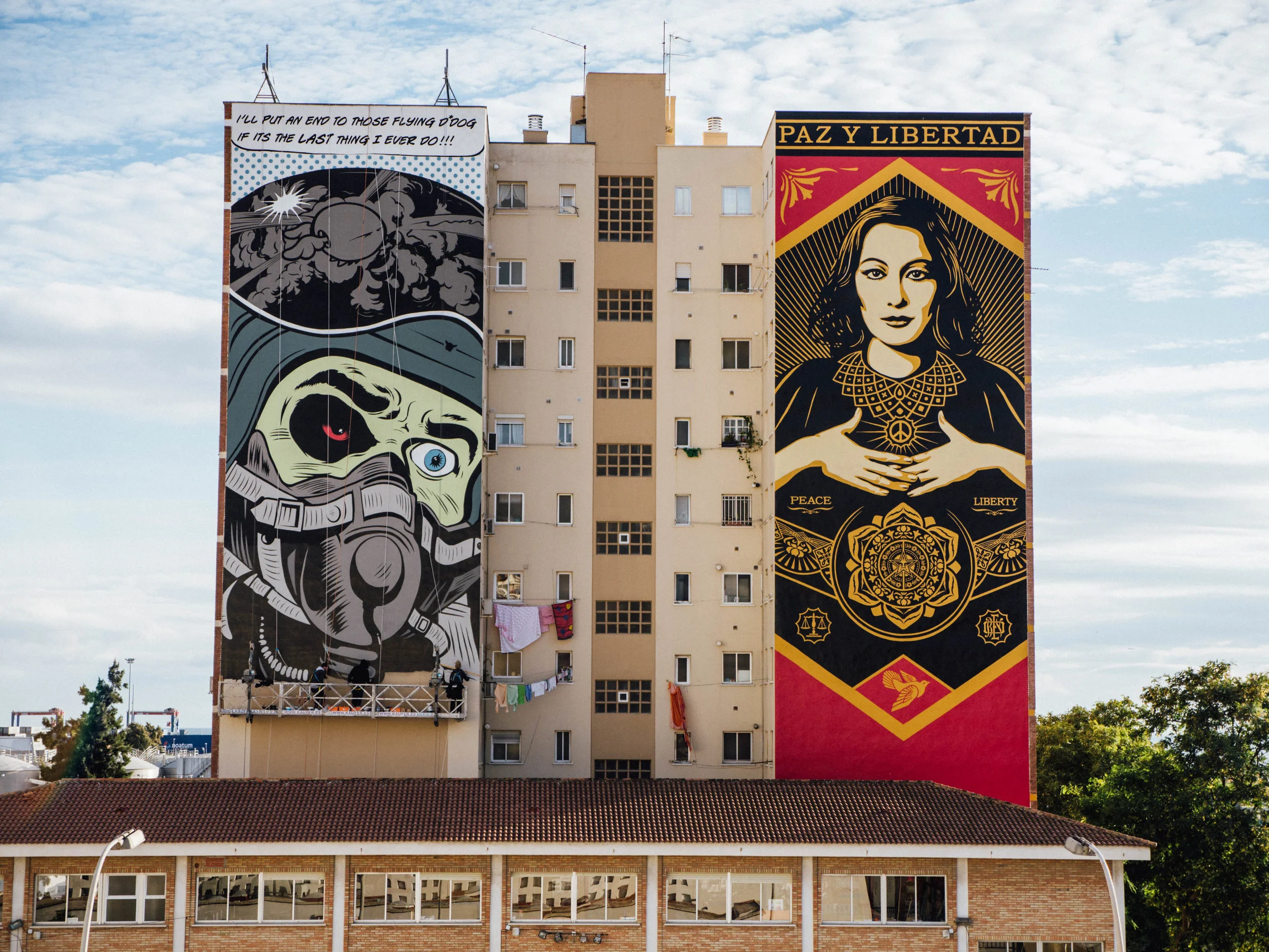 Alongside Shephard Fairey in Malaga commissioned by the UN. "You can just catch me at the end of the swing stage in that image :)" - Louis, Spraying Bricks