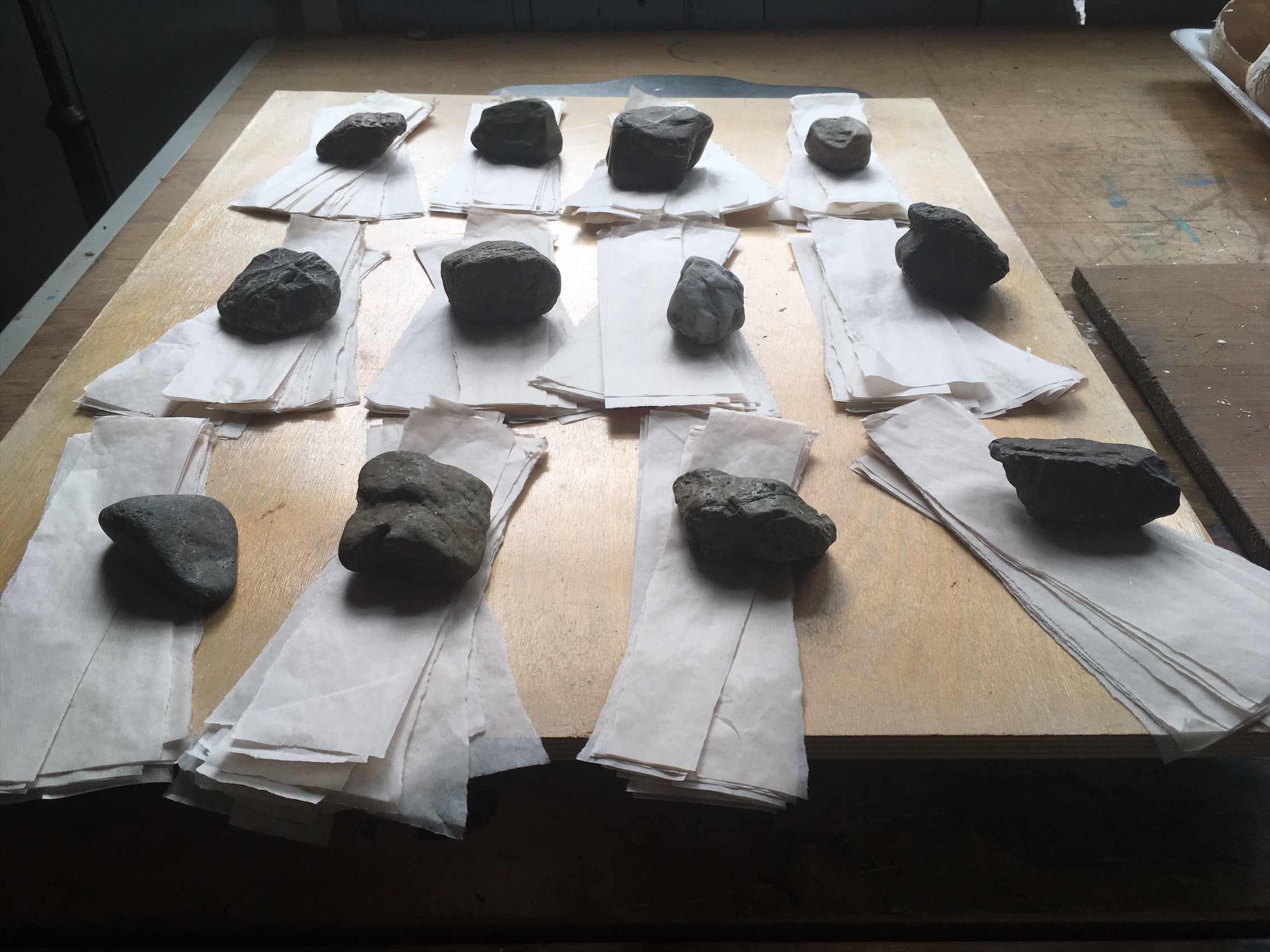 PHOTO 156 process - rocks and paper on drafting table.JPG