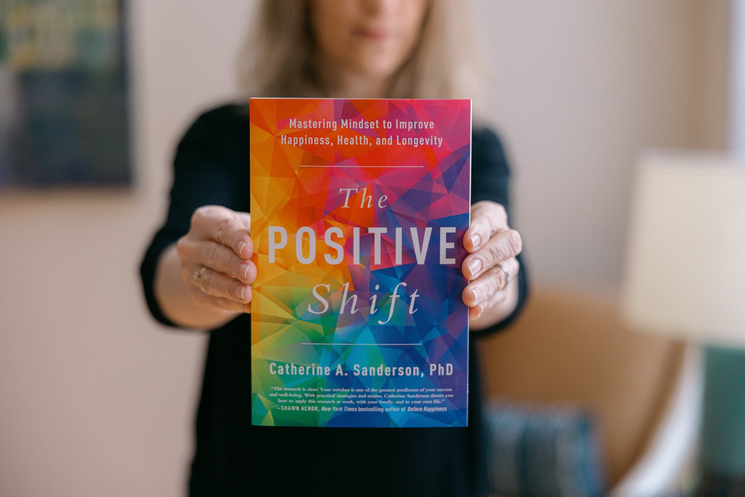 Catherine holds up her book, The Positive Shift