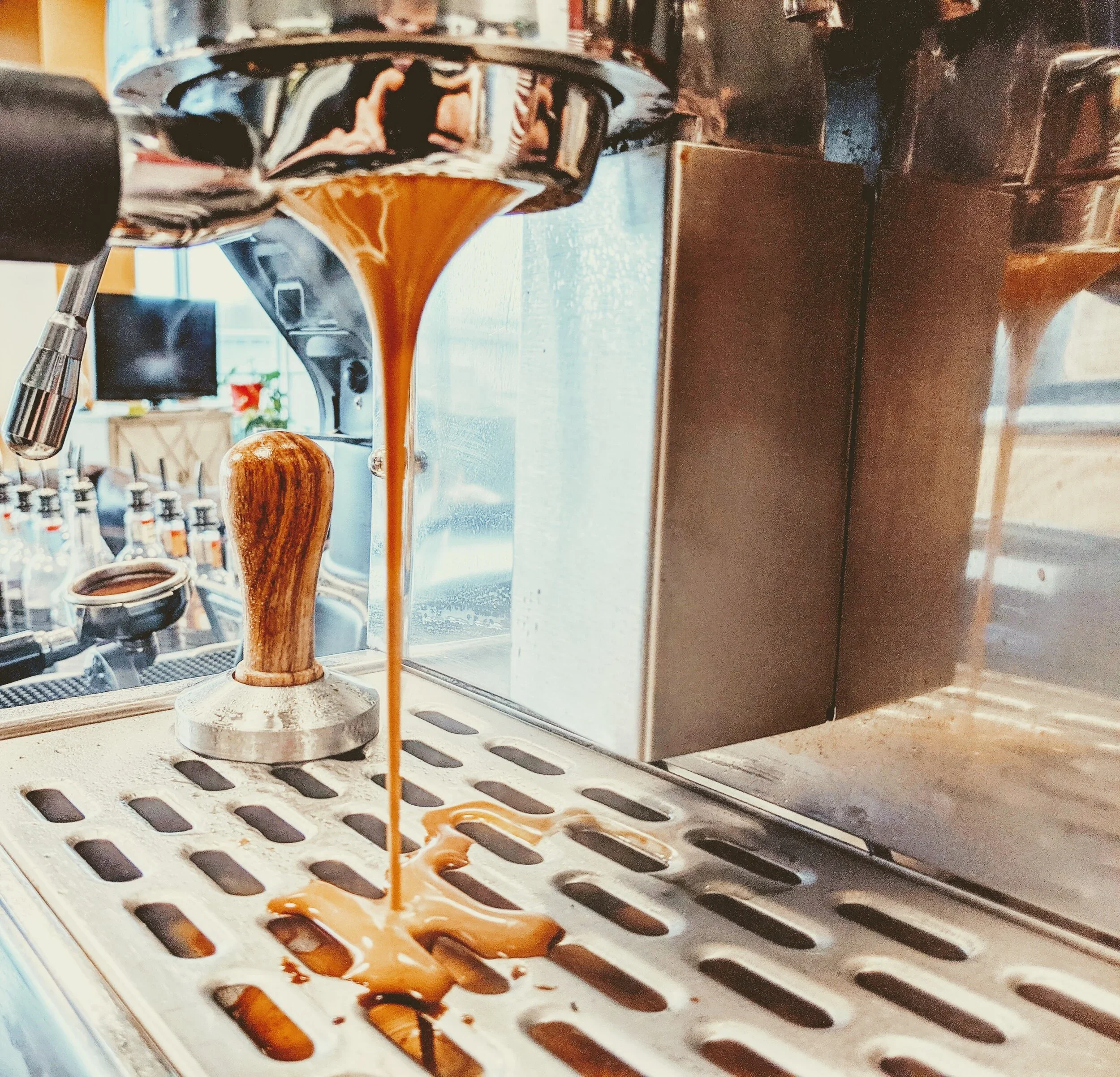 A close-up of a professional espresso machine pulling a fresh shot during a Brewin’ Around mobile catering event.