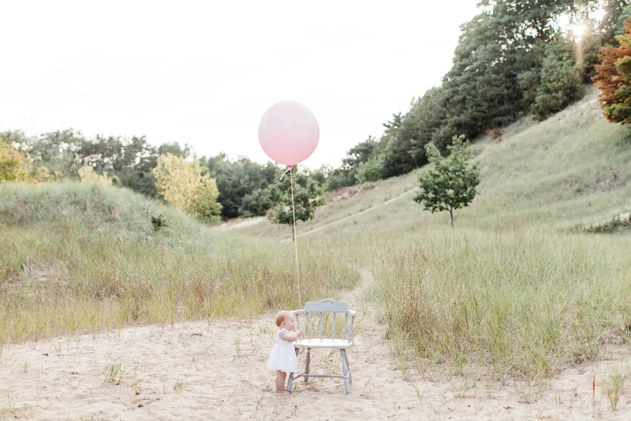 Pink ballon baby photography session in Grand Haven Michigan on a beach