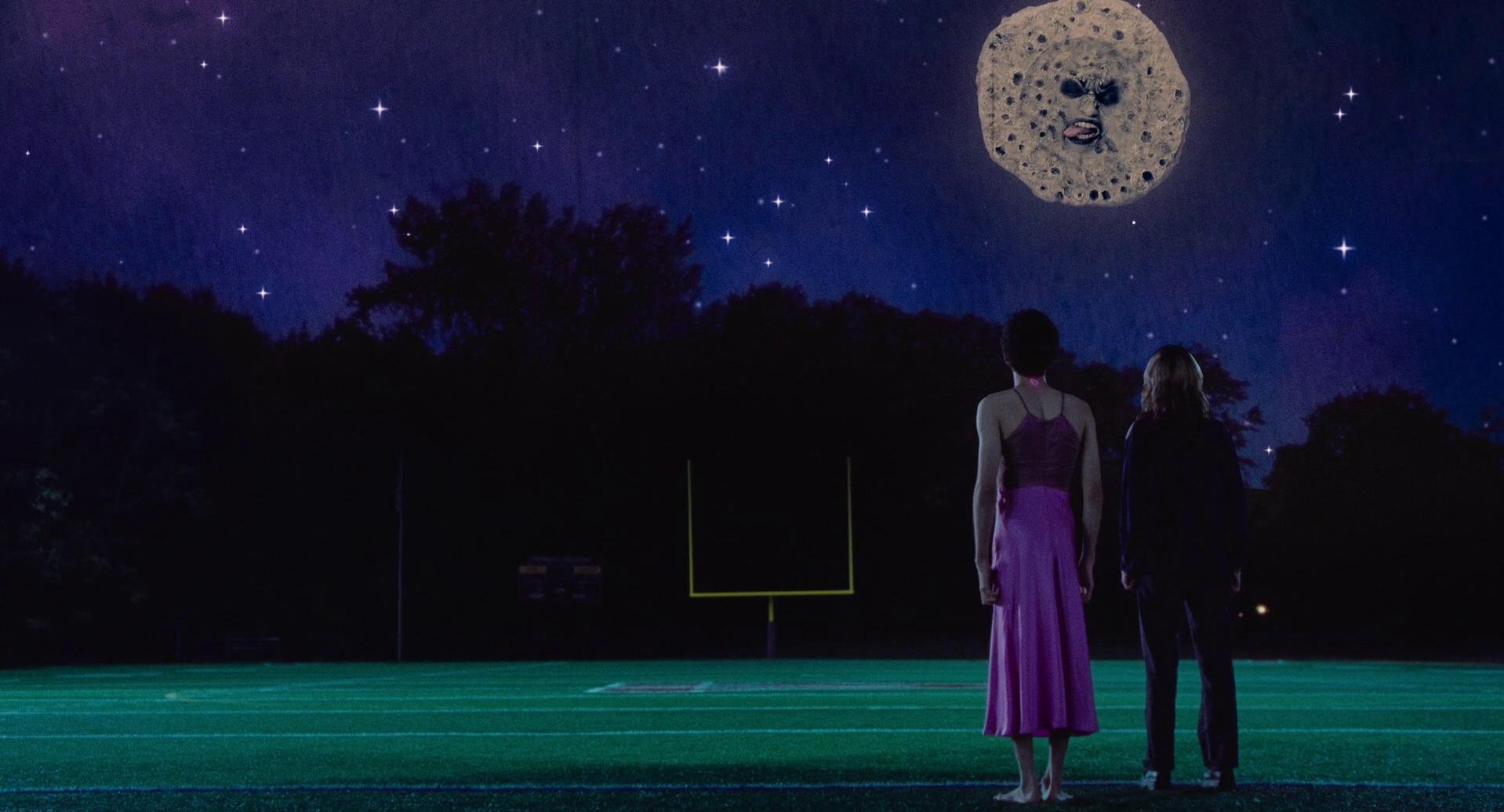 two-people-in-a-football-field-looking-upwards-towards-the-moon (1).jpg