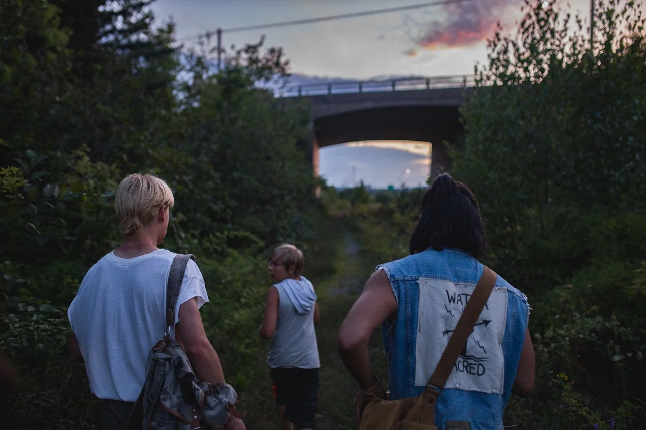 three-people-in-forested-area-walking-towards-underpass.jpeg