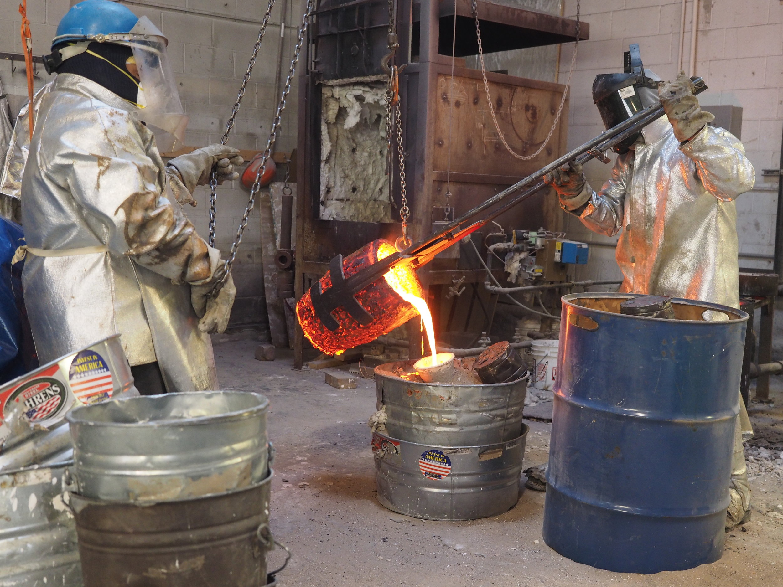  Molten bronze being poured into prepared ceramic shell mold. 