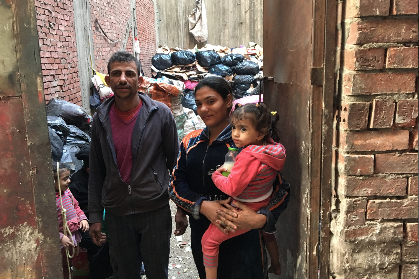 Saoud and her family in the courtyard where they sort trash.