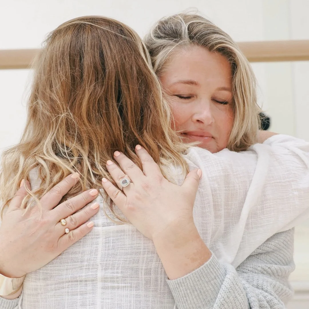 Two women hugging each other.