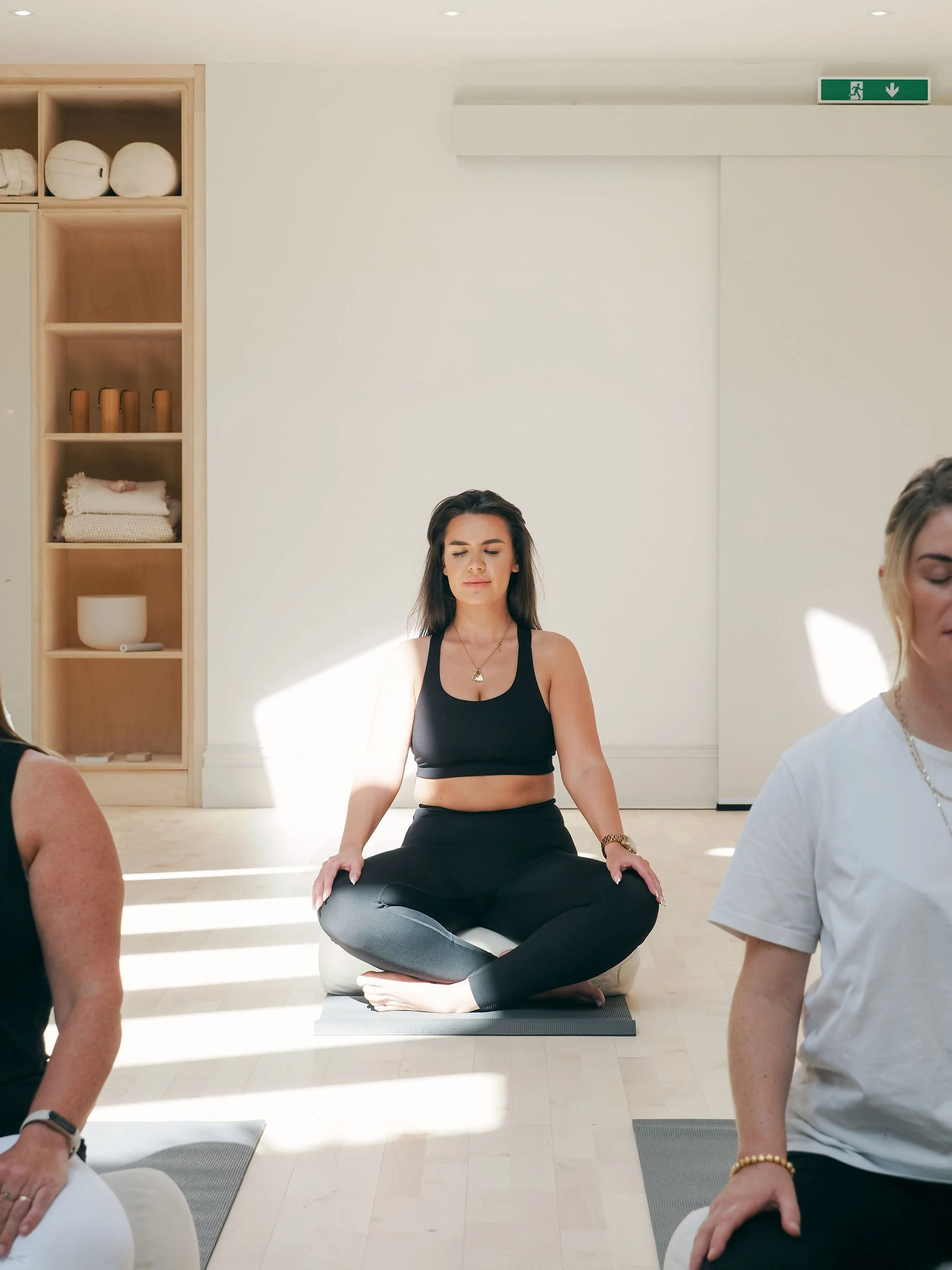 Women taking part in a guided breathwork session with Ellie Loves in a bright, calming studio.