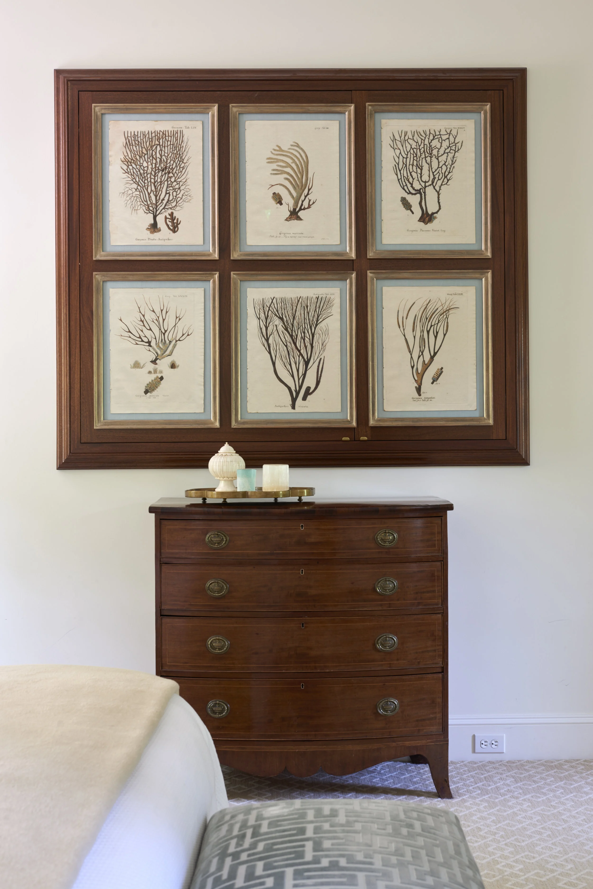 TV hidden behind a wall of coral branch prints