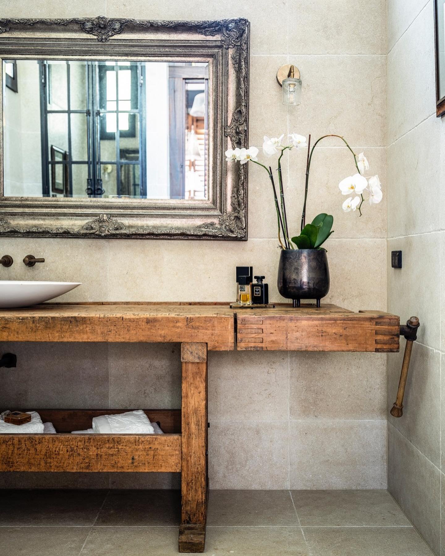 W A R E H O U S E &bull; We transformed an antique French carpenters workbench into a bespoke bathroom vanity for the powder room. Neutral tones and textures of Italian limestone with weathered brass tapware from @brodware Australia. Limestone @surfa