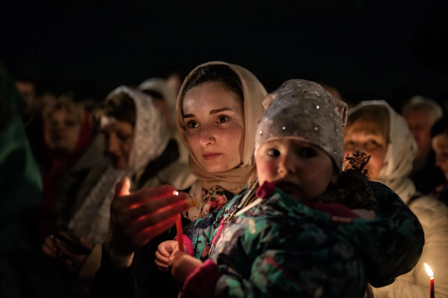 Rome, Italy, Apr 2018. Nataliya (32), a Ukrainian believer, just outside the church. She is waiting the divine liturgy to start. «The candle witness our faith, with it we become part of the divine light».