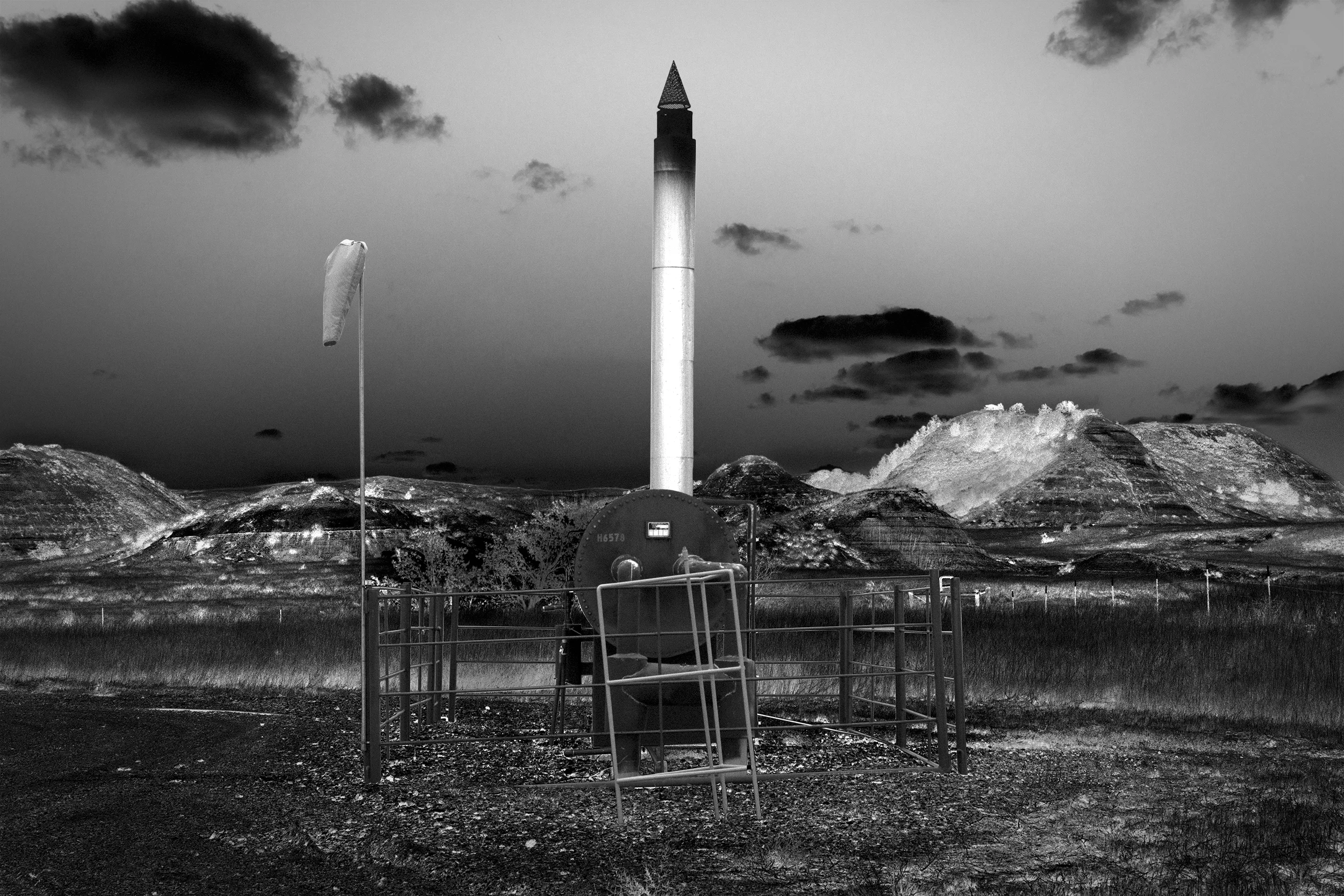 Poisoned Water Runs Deep Gina Glover’s dramatically entitled series of landscapes, documents fracking sites in the United States. These photographs show a variety of ordinary looking equipment, water tanks, pumps and pipes, which collect gas which is piped onward from the fracking site to a gas compression station. Mostly these occur on farmland, in some cases right beside where cows graze, or close to habitation.