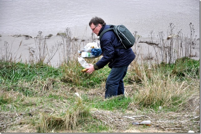 The artist collecting trash from beside the Great Ouse river for making into art as part of the Trash | Art show.