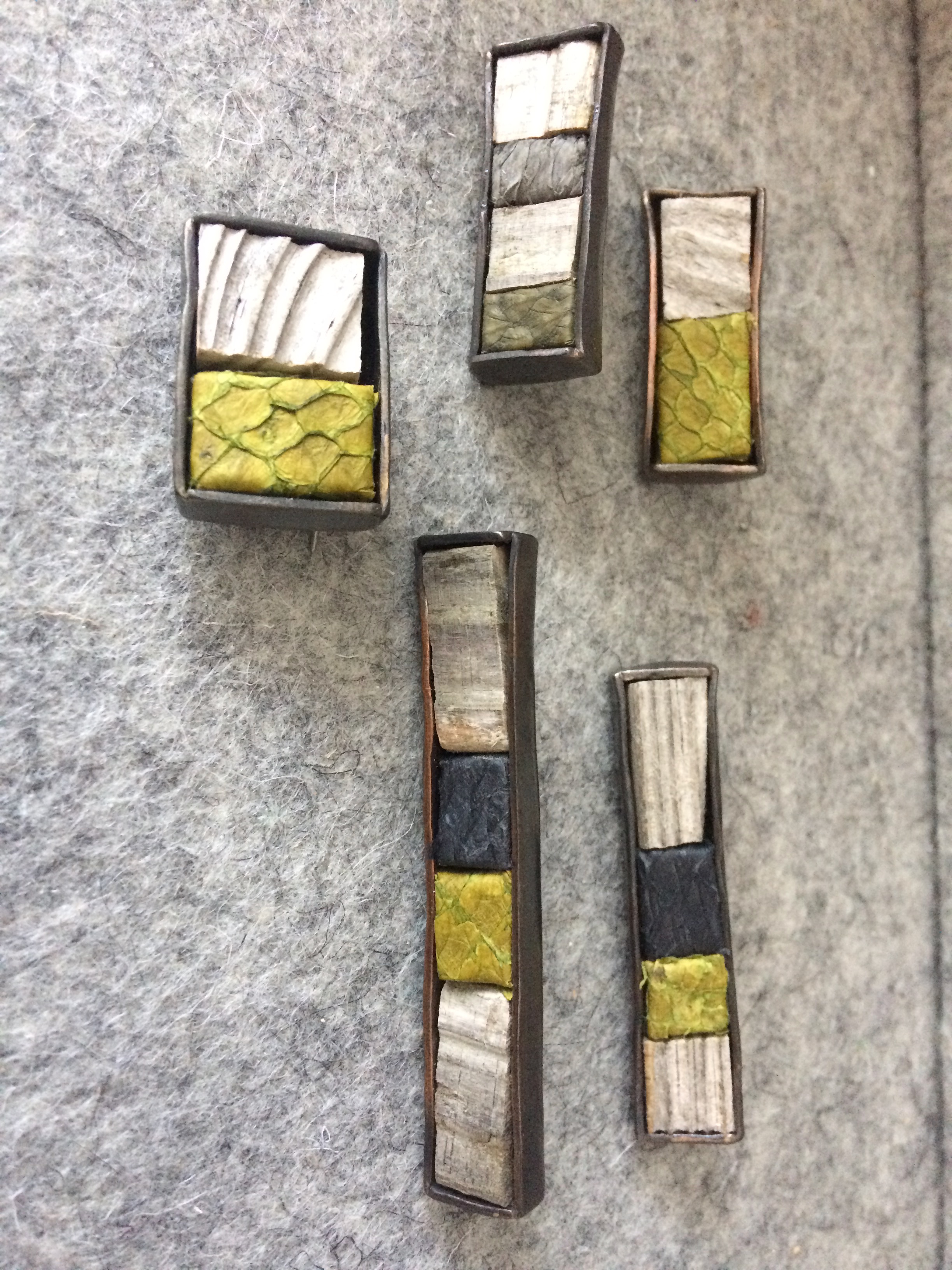 Helga Mogensen brooches (to be worn horizontally or vertically) made from driftwood and fish leather set in metal.