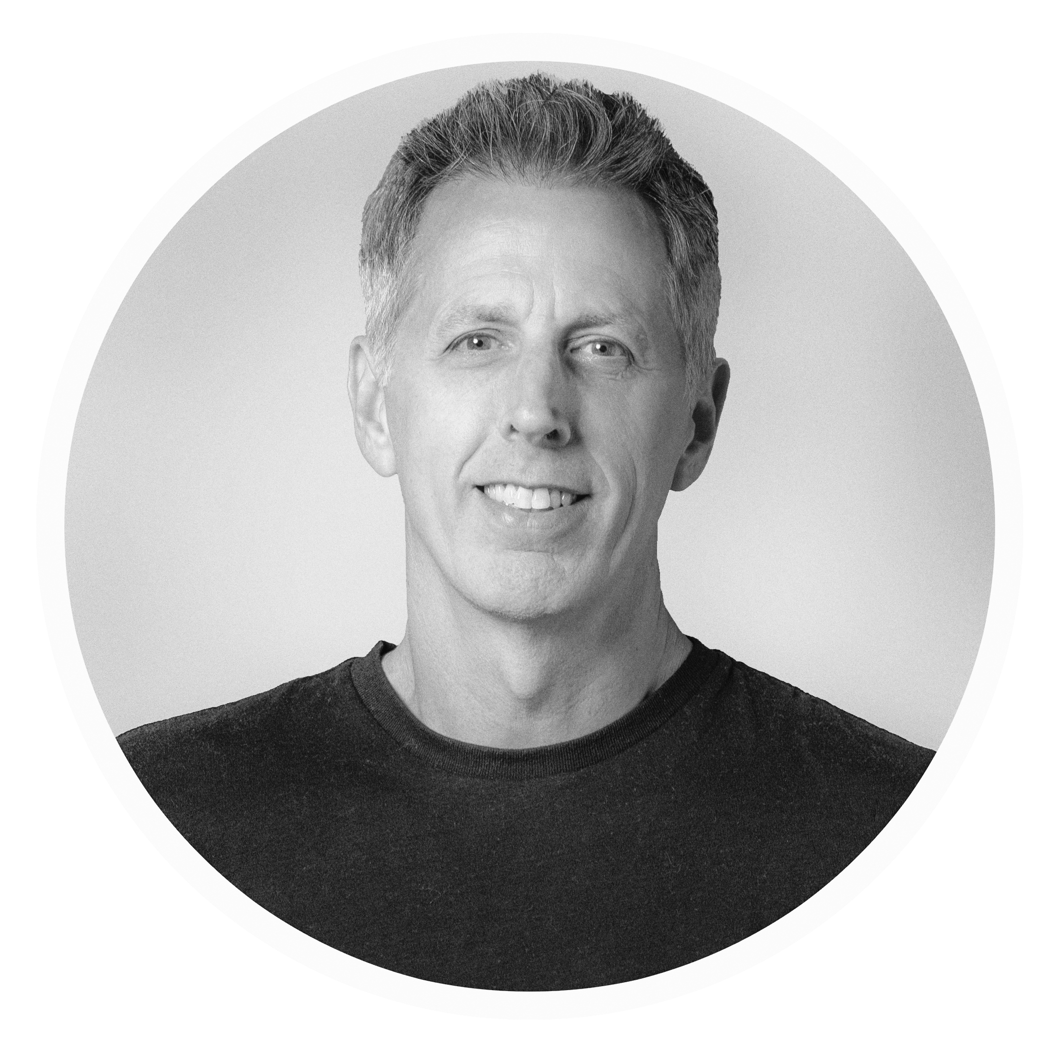 Black and white headshot of Shaun Cloud, wearing a dark t-shirt, against a light gray background.