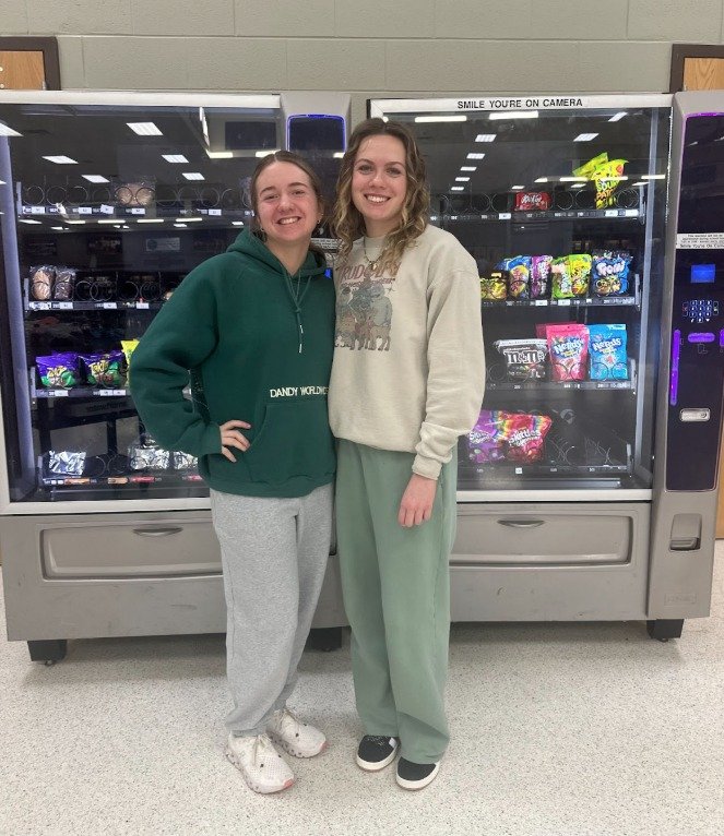 Camdenton DECA Students in front of Spirit Box vending machine