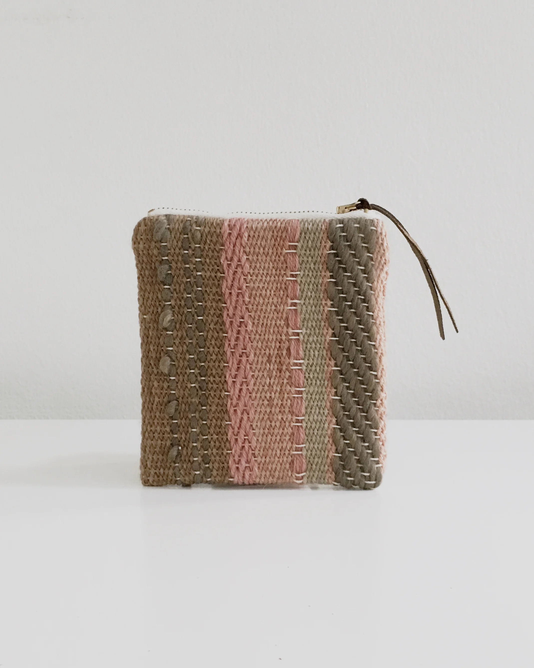 Handwoven zipper pouch made with plant dyed yarns and lined with botanically dyed linen. Unique and handmade artisanal piece.