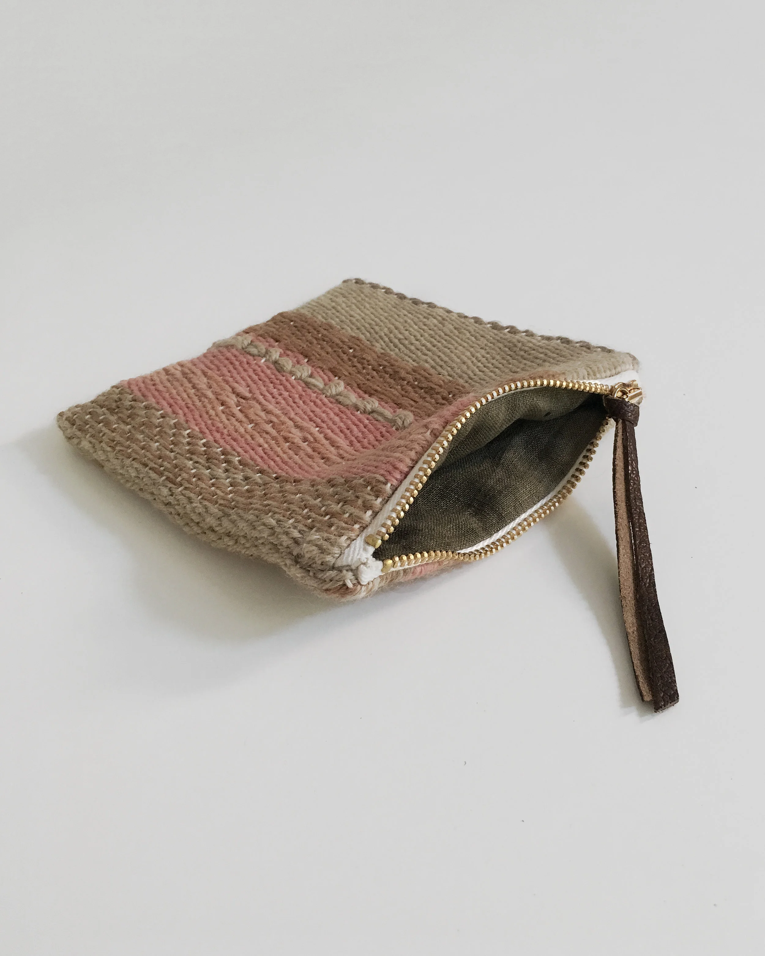 Handwoven zipper pouch made with plant dyed yarns and lined with botanically dyed linen. Unique and handmade artisanal piece.