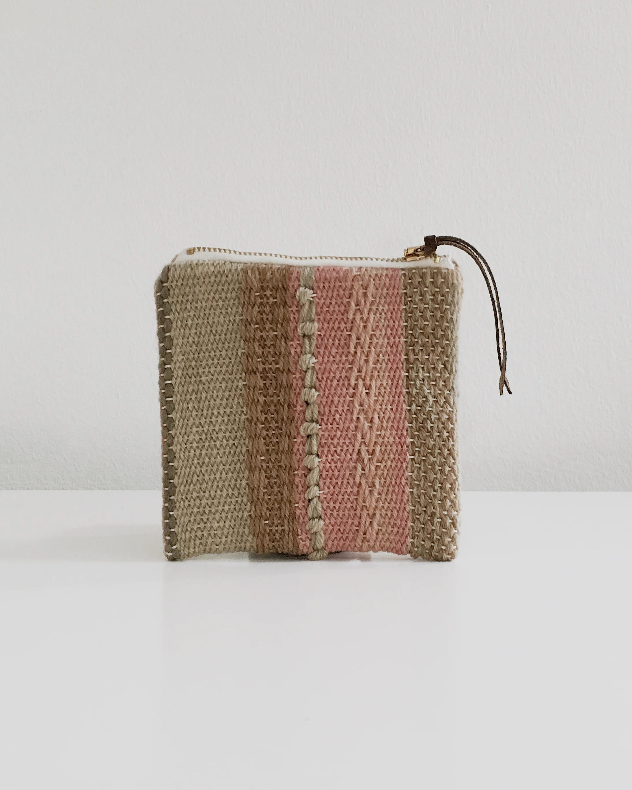 Handwoven zipper pouch made with plant dyed yarns and lined with botanically dyed linen. Unique and handmade artisanal piece.