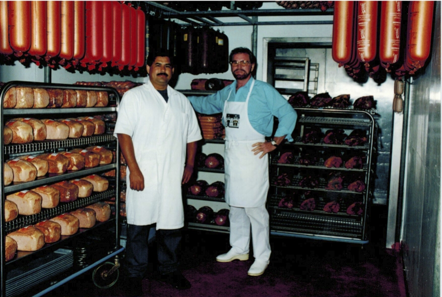 WURSTMACHER EUGEN GOETS (RIGHT) WITH SAM HERNANDEZ (LEFT) STANDING IN ONE OF CONTINENTAL'S DELICIOUSLY FILLED SAUSAGE WALK-IN COOLERS.