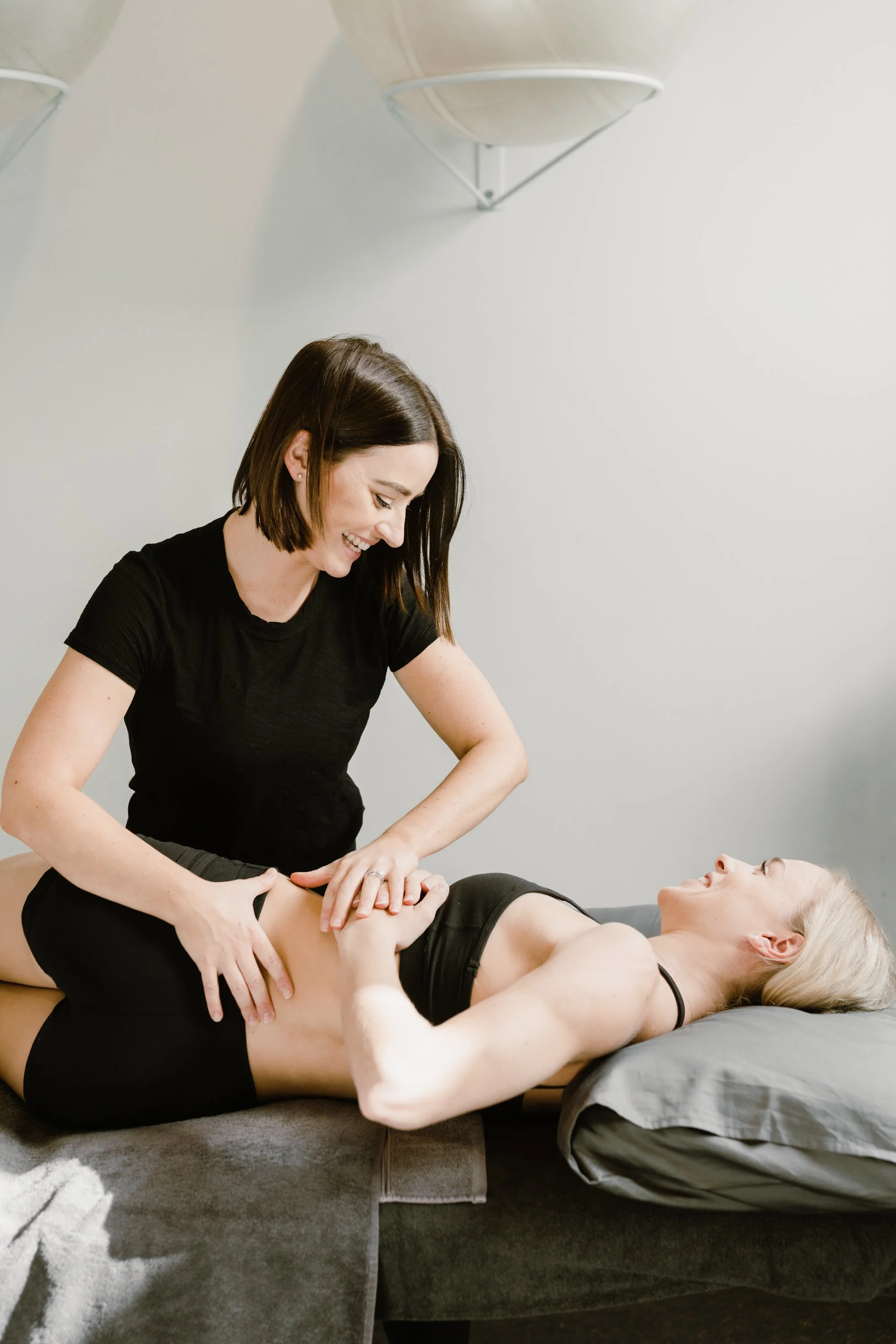 A woman receiving a massage from a massage therapist in a wellness center.