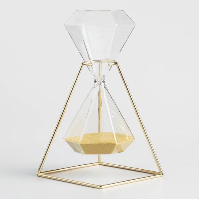 A hexagonal hourglass in a gold base. It is about 25 x 12 x 12 cm. The height of a beer bottle. A lovely decorative piece.