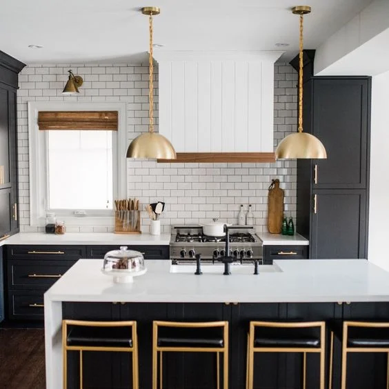 Royce Chain Pendant. Source: Schoolhouse. Rather than small pendants the homeowner choose two larger gold tone ones. This pendant is also gold toned on the inside. The brass barstools pick up on the gold tones. I probably would have chosen a more interesting fabric for the barstools. The, what looks like faux leather in black does not do it for me. This would have been a great opportunity to introduce an interesting floral or geometric fabric design. The white subway tile is perfect and works well with the countertops. The black faucets are great. A brass toned faucet set would work equally well here.
