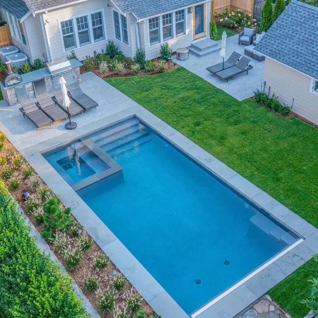 This backyard oasis features a porcelain patio paired with a bluestone pool coping, crafted by our team at Gault Stone. A perfect balance of style and relaxation for next summer living.