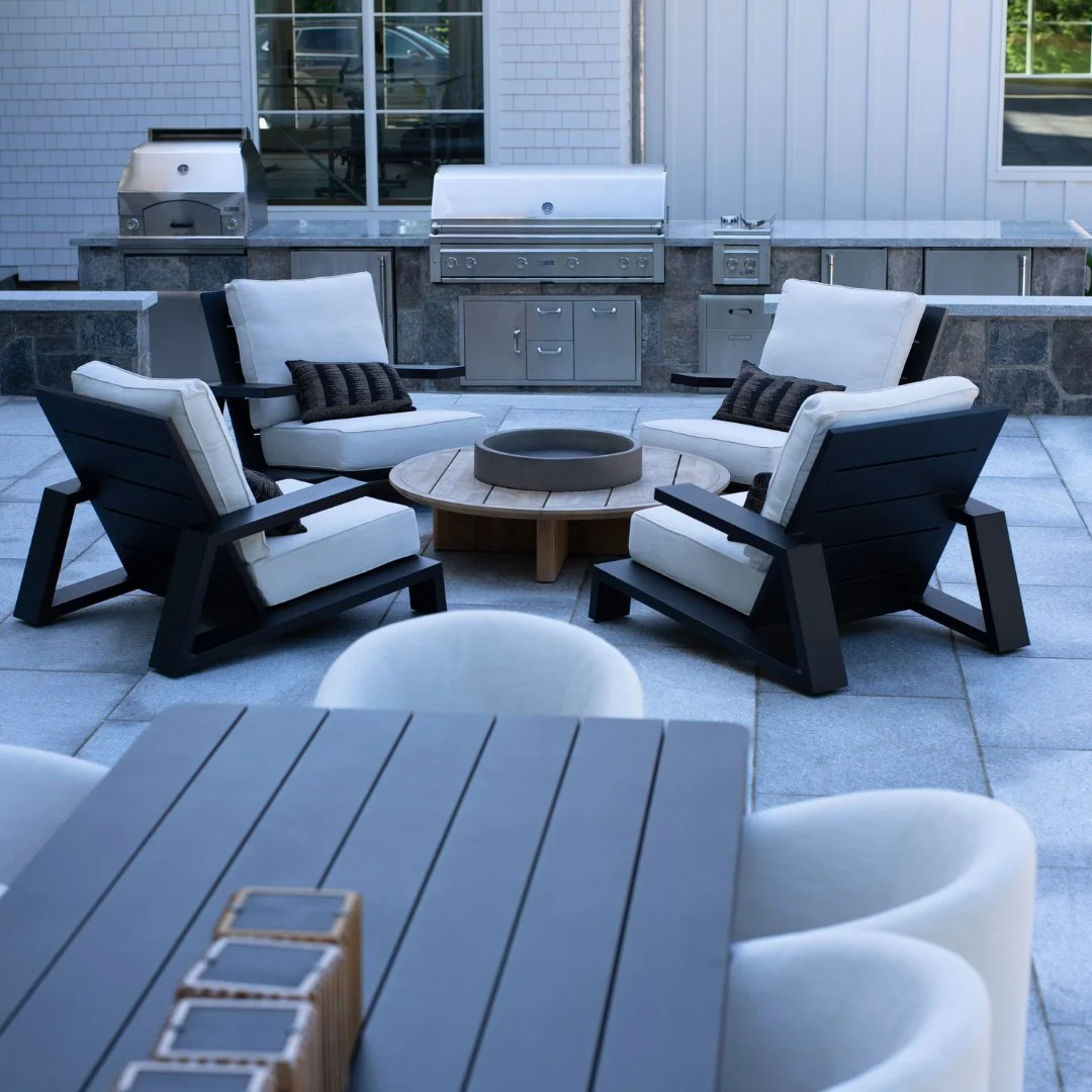 Where every season is grilling season, even in the cold! This Chatham Grey patio combines a cozy fire pit, inviting seating, and an outdoor kitchen designed for effortless entertaining, featuring a Chatham Grey honed countertop and Liberty Hill base.