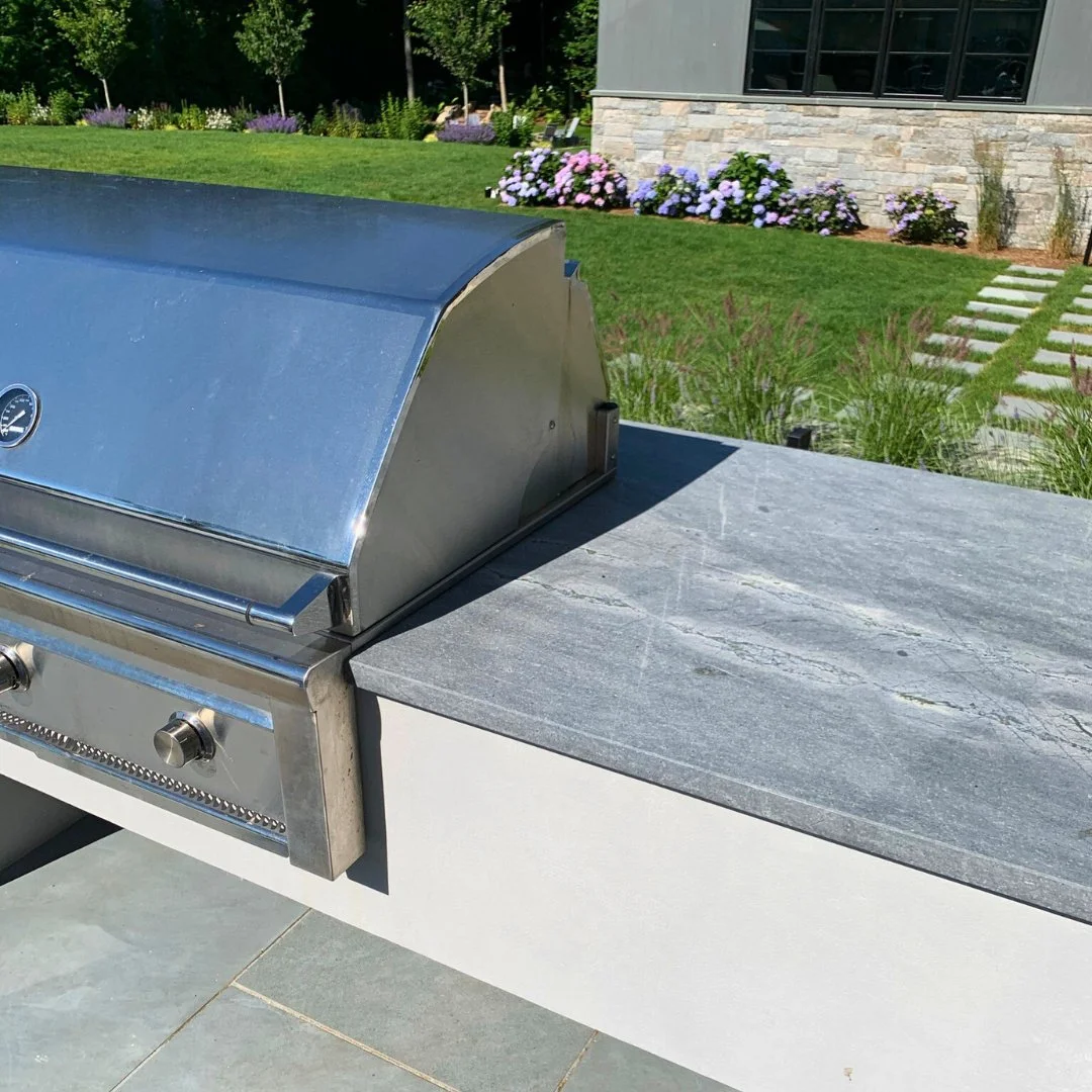 Even in December, great design brings people outdoors. With a polished granite countertop and custom-built grill surround, this outdoor kitchen is ready for gatherings all year long.